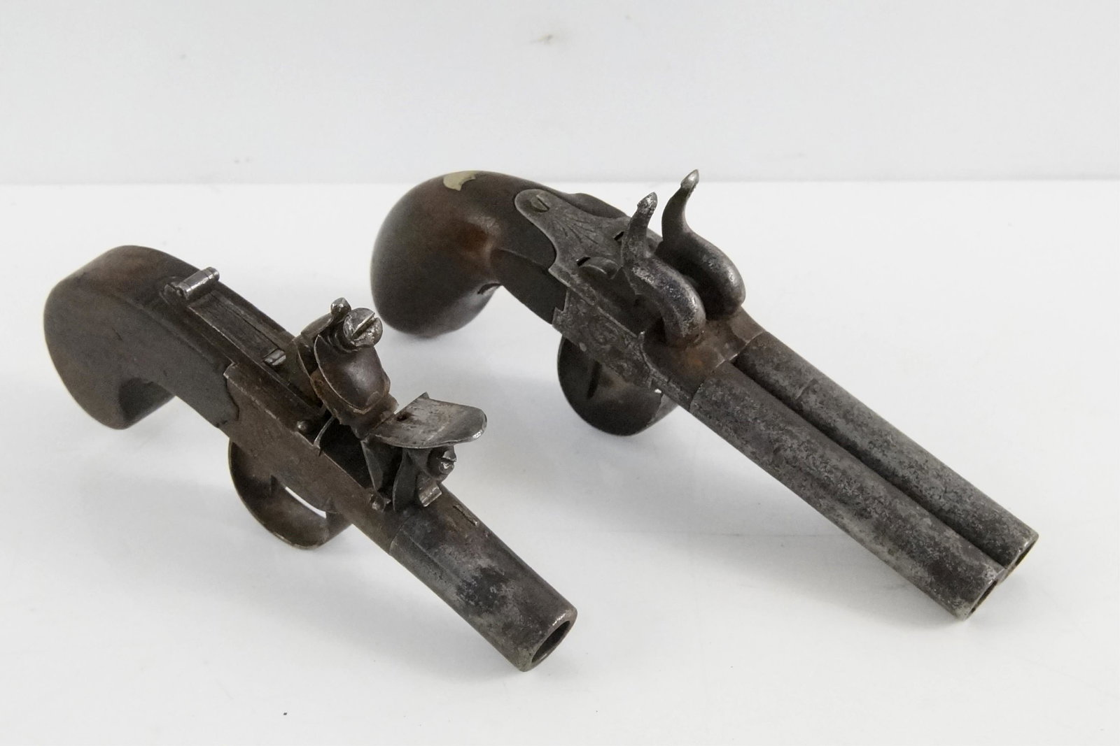 Antique percussion and Flintlock Pistols: 2 pcs, including a Hinks Flintlock circa 1820 and a double barrel engraved Percussion derringer with walnut handle and silver mounted shield
