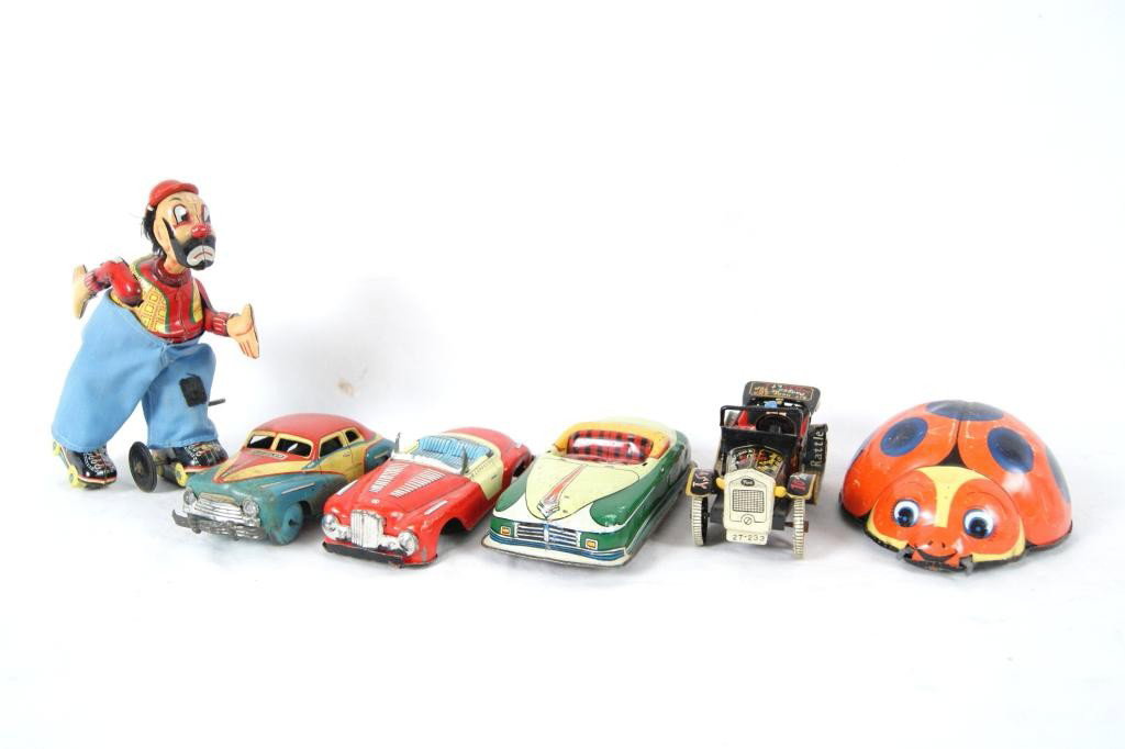 Vintage Japanese Wind-up Toys: Wind-up clown on roller skates, Vintage 1952 Chrysler wind-up car, Vintage Jaguar friction car, 1940s Nash vintage friction car, Graffitti covered vintage Ford Model T push car, Wind-up orange and blu