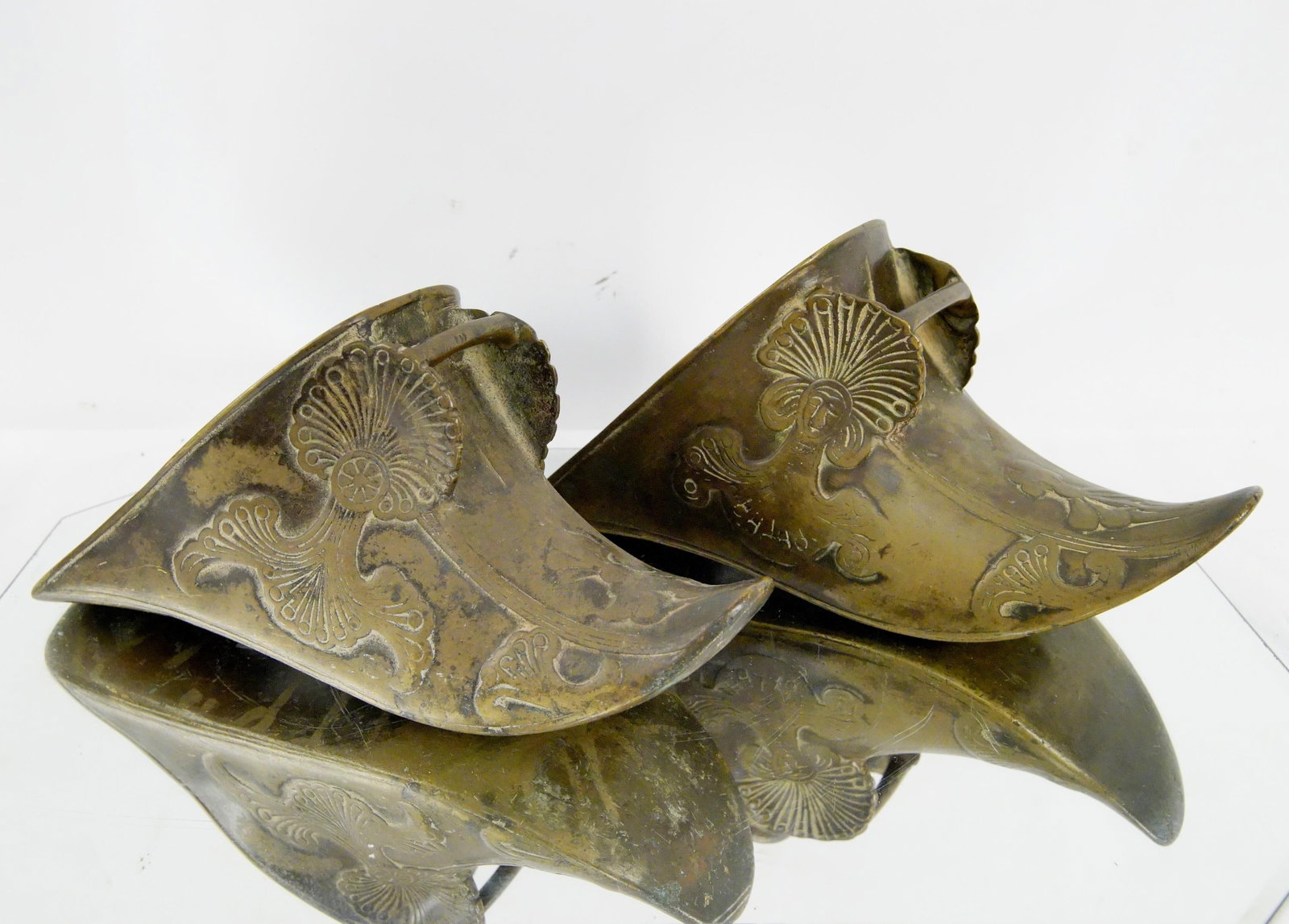 Antique Spanish Colonial Brass Stirrups: heavily embossed cast and assembled Spanish Colonial Pair of 19th century, or earlier, brass slipper stirrups. The elaborate casting mimics in brass the shape and decoration of a traditional leather b