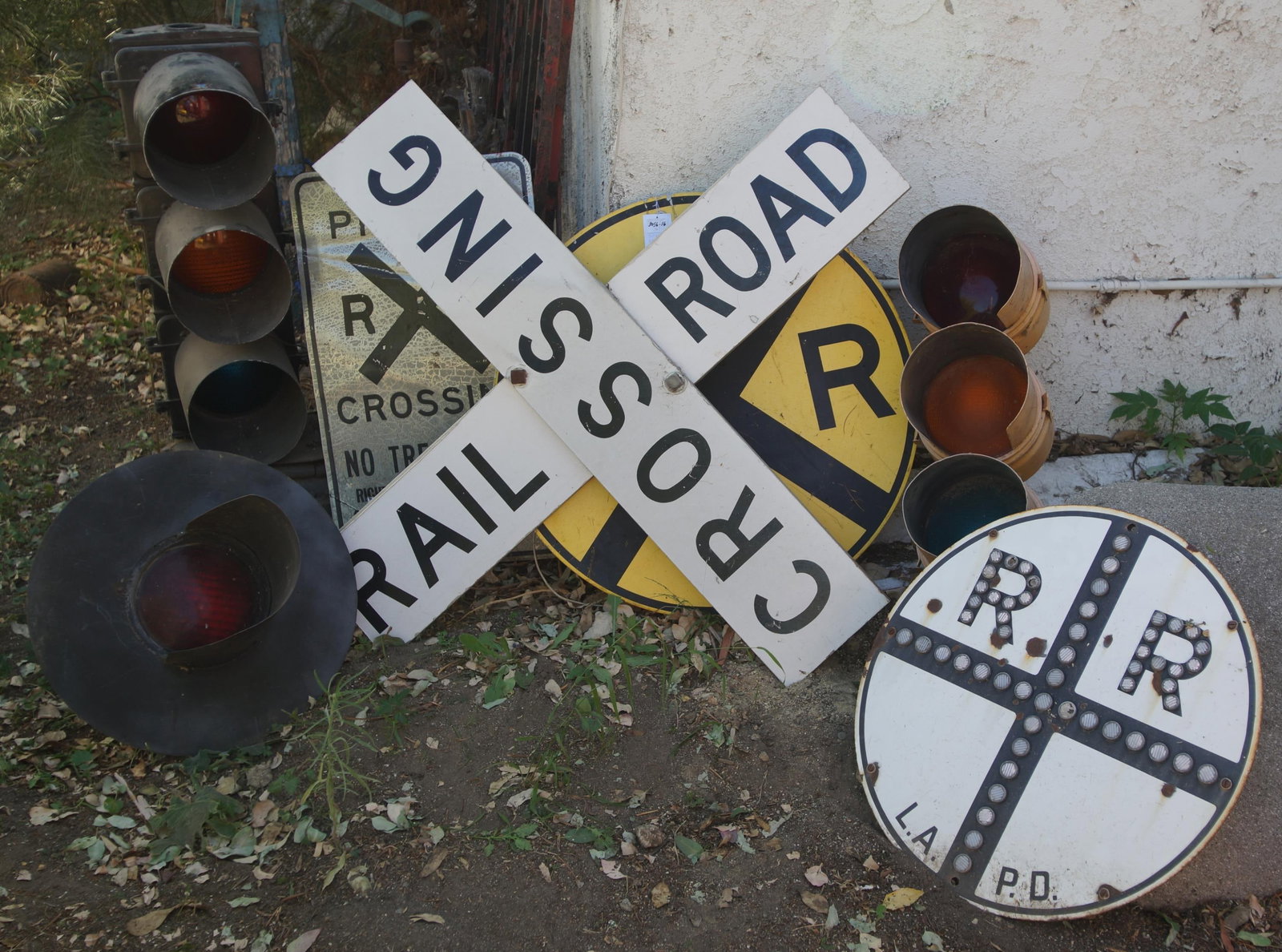 7 Vintage Rail road signs and lights: a 30" RR sign, A 23.75" LAPD RR sign, a 30" x 18" Private RR Crossing No Trespassing, a 22" x 30" RR light fixture, a 40" x 40" diagonal RR sign, and two 3-light signal lights at 31" and 26"