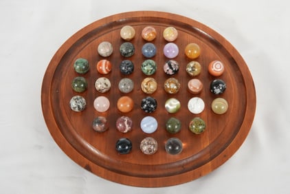 Collection of marble puzzle in wood tray
