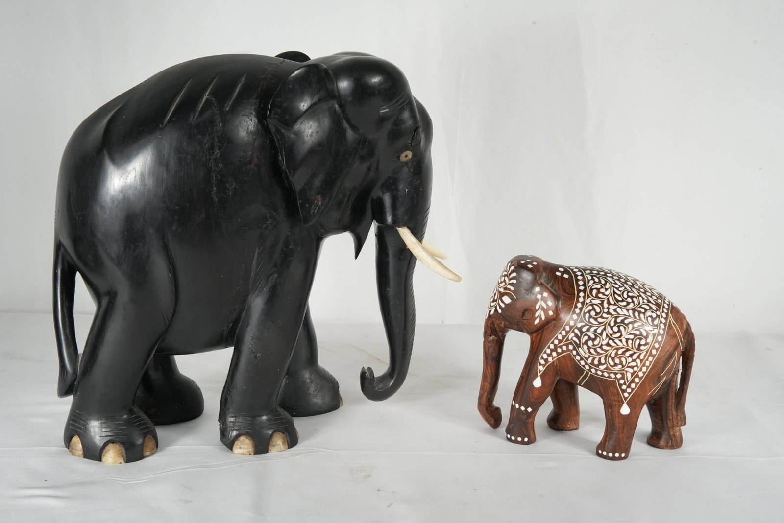 2 Vintage Wood Carved Elephants: Two hand-carved wooden elephant figurines. The Large Elephant s is a vintage African ebony elephant sculpture, hand-carved from dark, dense ebony wood. Ioff-white bone tusks probably made in Ceylon (S