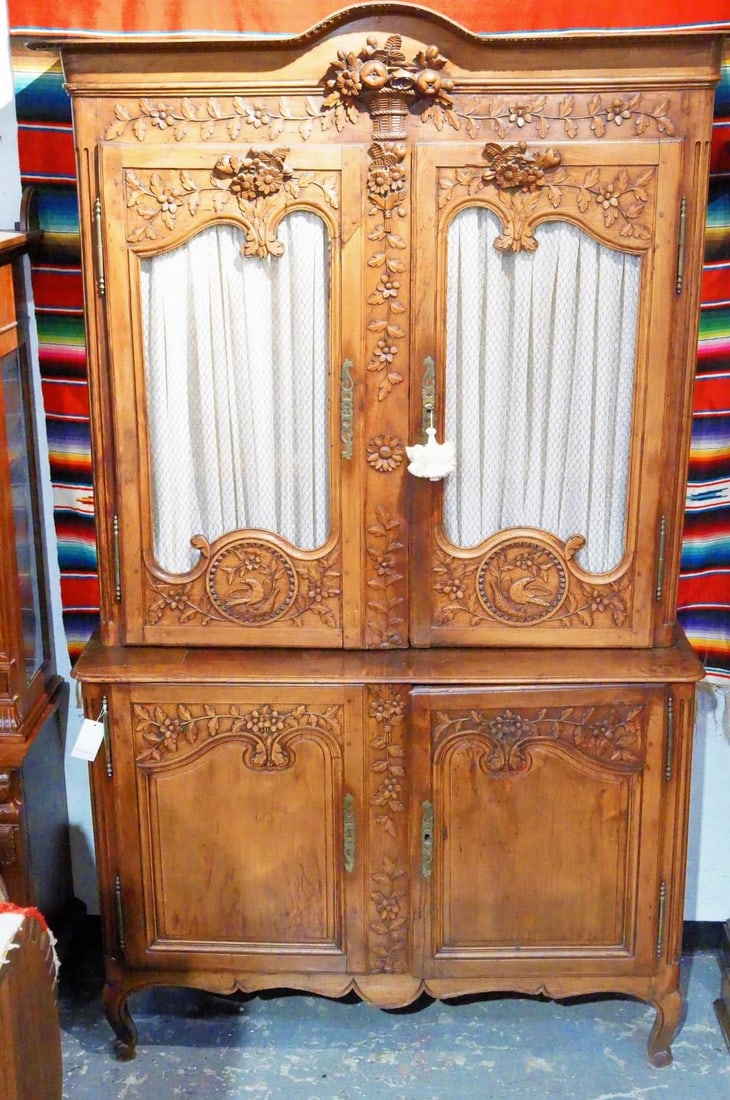 Highly Carved Louis XVI Antique French Cabinet: Aesthetically French carved bonnet with repeating dental border in the form of half blooming flowers with a central cornucopia basket spilling with fruit and flowers. Vining leaf pedals and