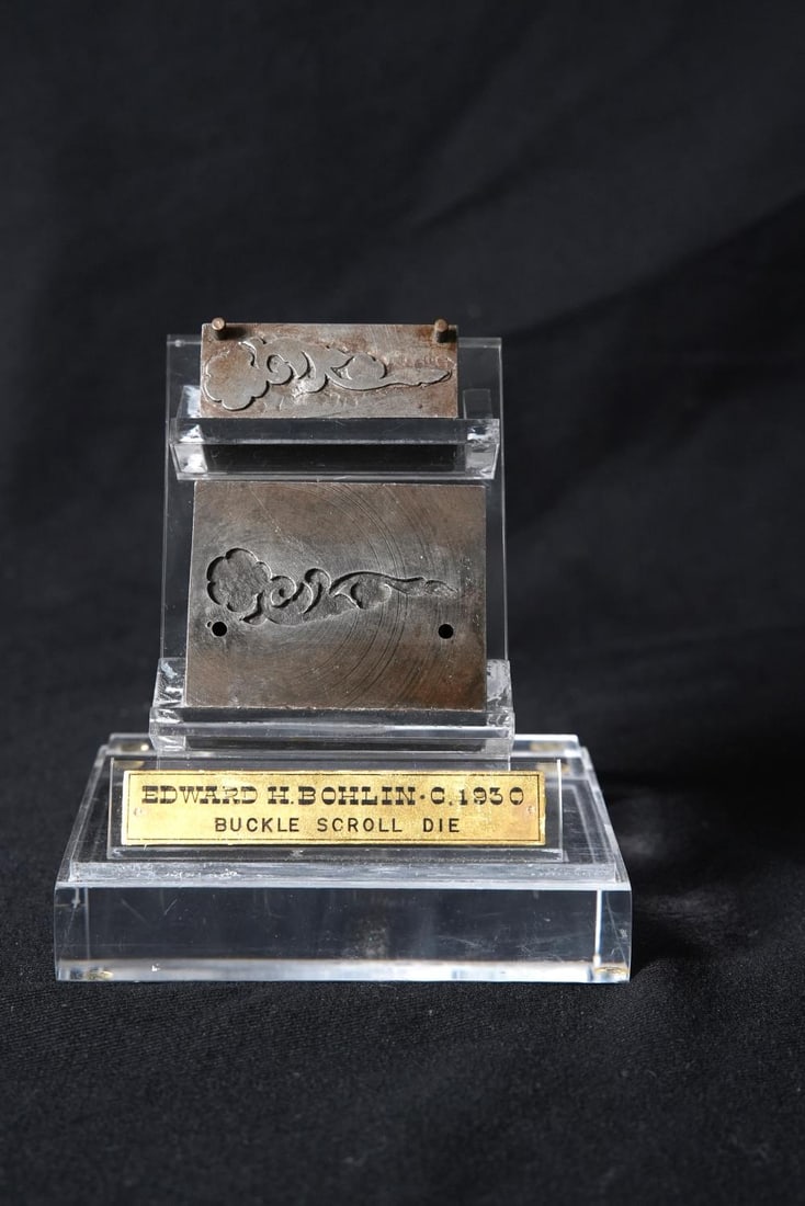 Edward H. Bolin Buckle Scroll Dye Presentation Circa 1930.: Edward H. Bolin Buckle Scroll Dye Presentation Circa 1930. Both steel Dyes are marked EHB (Edward H. Bohlin) and they both fit on a 6.5" x 4.75" x 3 7/8" plexi stand with presentation badge.