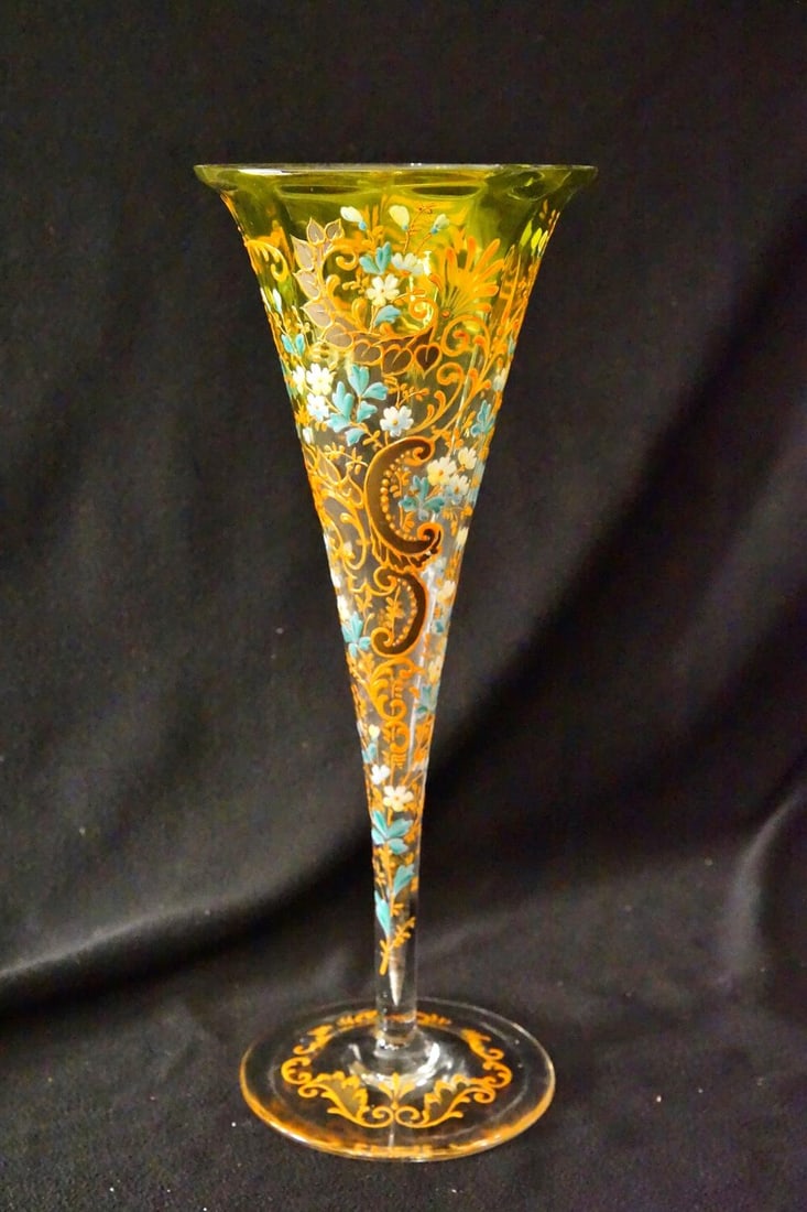 19th Century Bohemian Enameled Glass Trumpet Vase: A Bohemian Moser-type enameled glass trumpet vase produced circa 1890 to 1910 features an elongated body transitioning from a clear stem and base into an olive green flared rim. The exterior surface