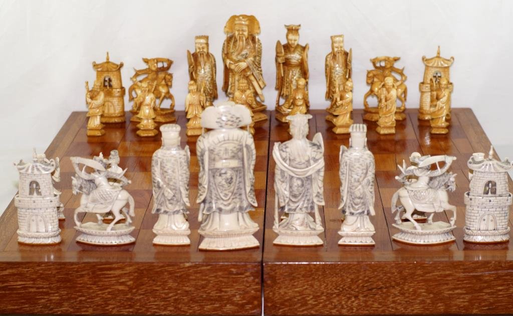 Outstanding 19th c Chinese Carved ivory Chess set: Kings measures 6.25", Queen measure 5.5" Bishop 5" x rook 4.25", Knight 54" Pawns 3" Highly carved antique Chinese chess pieces - black pieces - tea stained - Kings depict dragons on robe,queens have