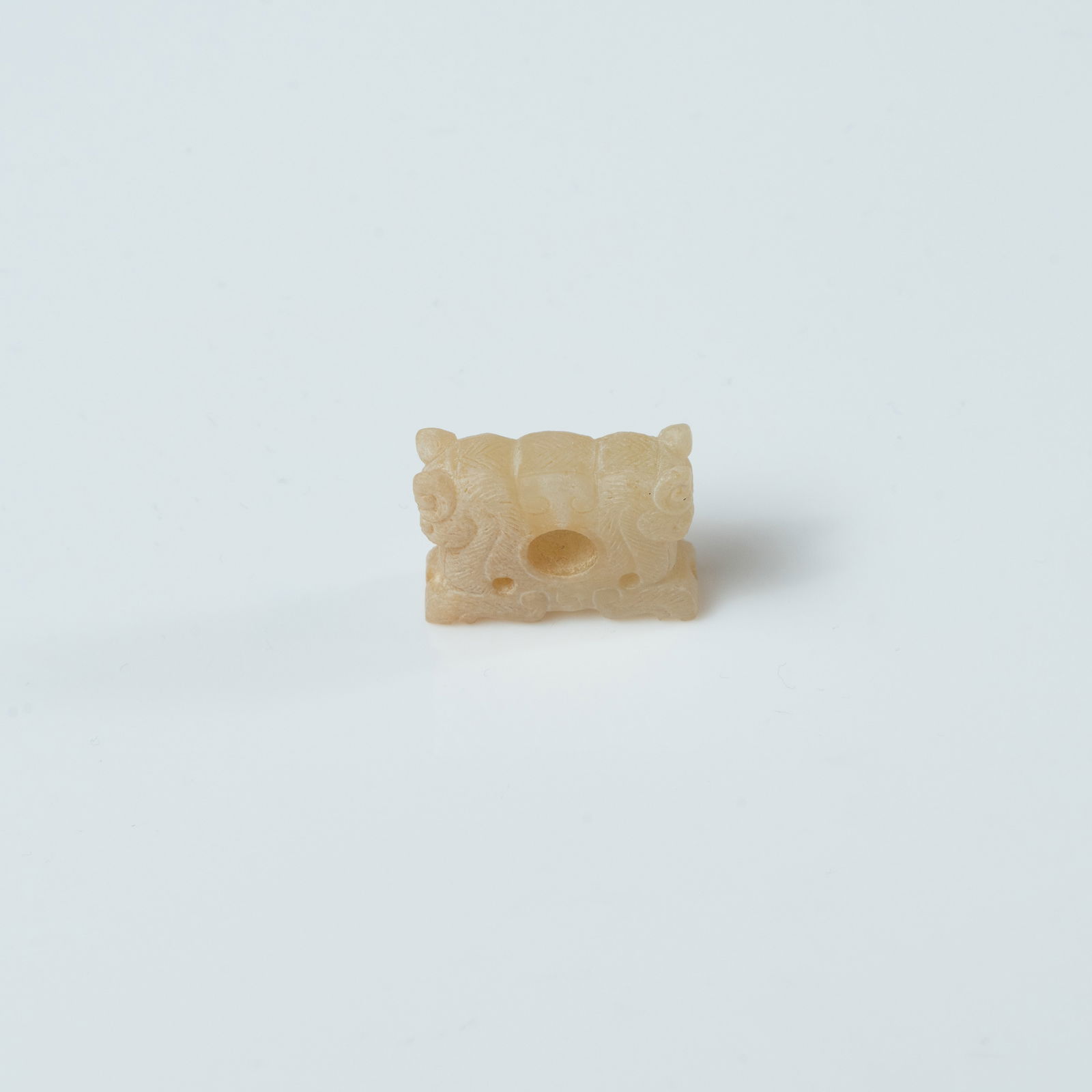 A RARE AND FINELY CARVED YELLOW JADE 'TWIN BEAST-MASK' ORNAMENT HAN DYNASTY (202 BCE – 220 CE): A RARE AND FINELY CARVED YELLOW JADE 'TWIN BEAST-MASK' ORNAMENTHAN DYNASTY (202 BCE – 220 CE)汉代 黄玉双兽面纹饰MEASUREMENTSL. 2.5 cm (1.0 i