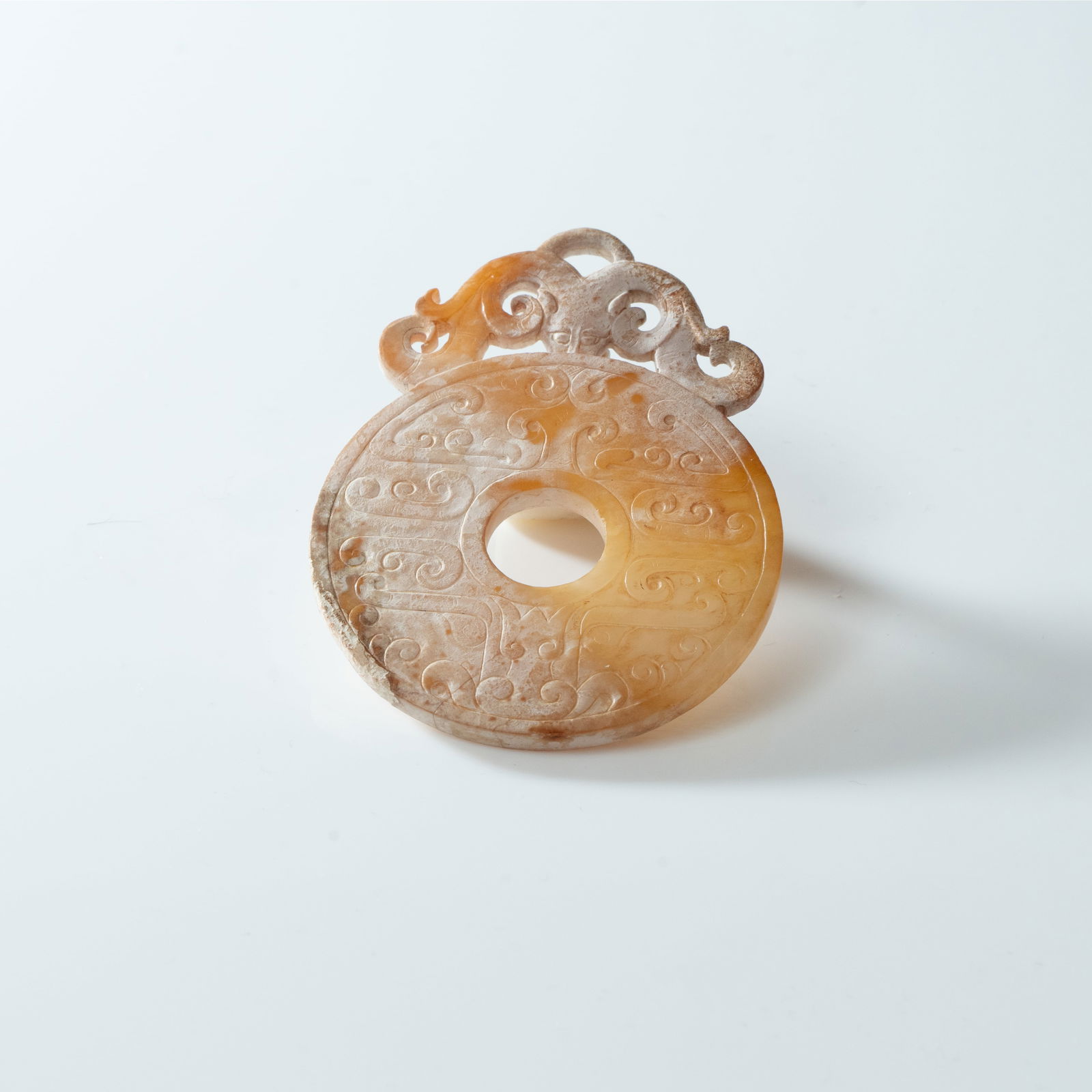 A CELADON AND CALCIFIED JADE 'DRAGON' BI-DISC (CHU KUO BI) STYLE OF HAN DYNASTY (1 of 2)