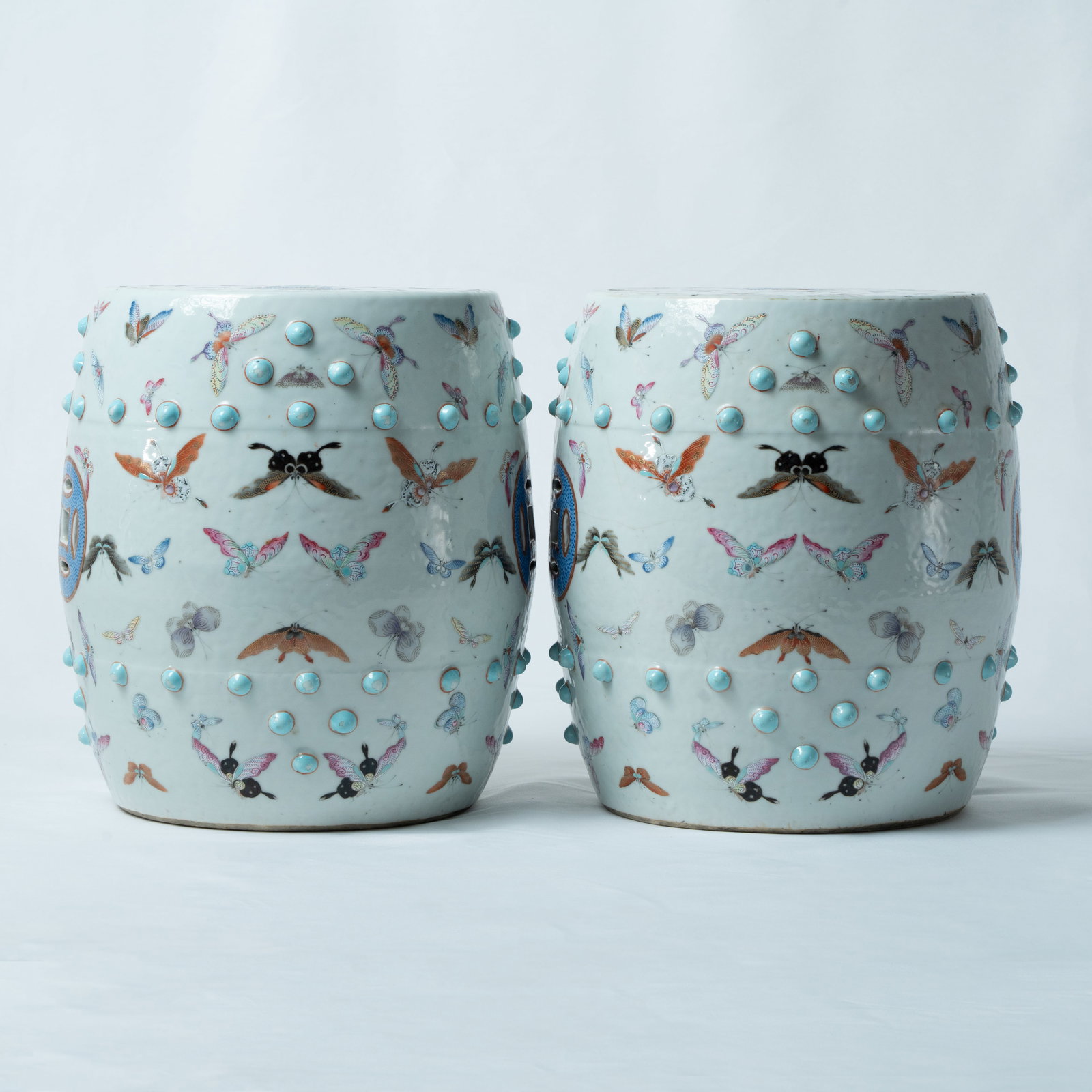 A PAIR OF FAMILLE-ROSE 'HUNDRED BUTTERFLIES' GARDEN STOOLS LATE QING DYNASTY, 19TH CENTURY: A PAIR OF FAMILLE-ROSE 'HUNDRED BUTTERFLIES' GARDEN STOOLSLATE QING DYNASTY, 19TH CENTURY晚清 粉彩“百蝶千卉”纹鼓钉坐