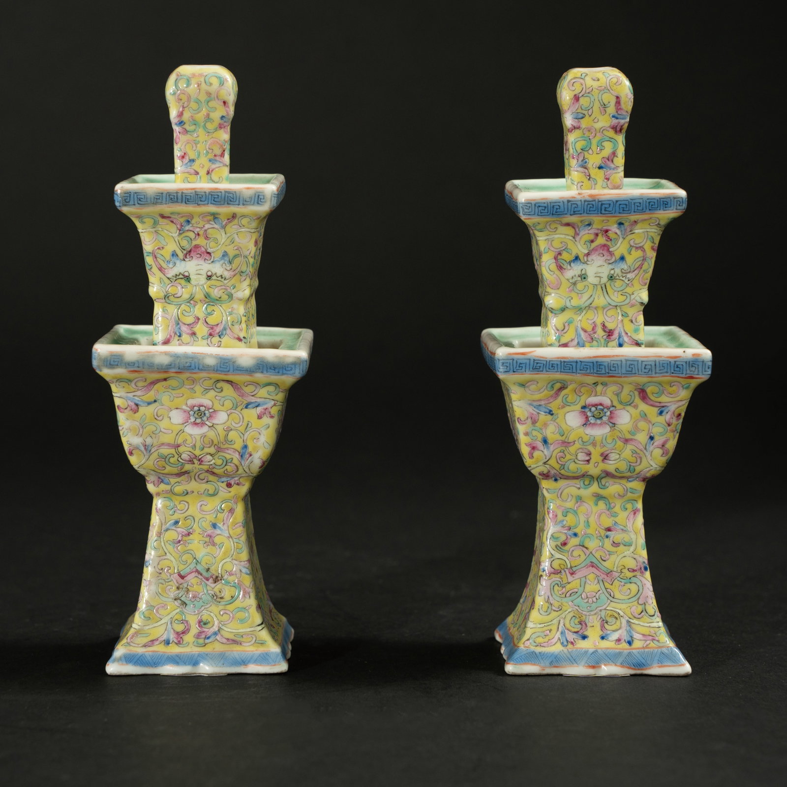 A PAIR OF YELLOW-GROUND FAMILLE ROSE 'FLORAL' THREE-TIERED SQUARE STUPA CANDLESTICKS JIAQING PERIOD,: A PAIR OF YELLOW-GROUND FAMILLE ROSE 'FLORAL' THREE-TIERED SQUARE STUPA CANDLESTICKSJIAQING PERIOD, QING DYNASTY清嘉庆 黄地粉彩花卉纹方