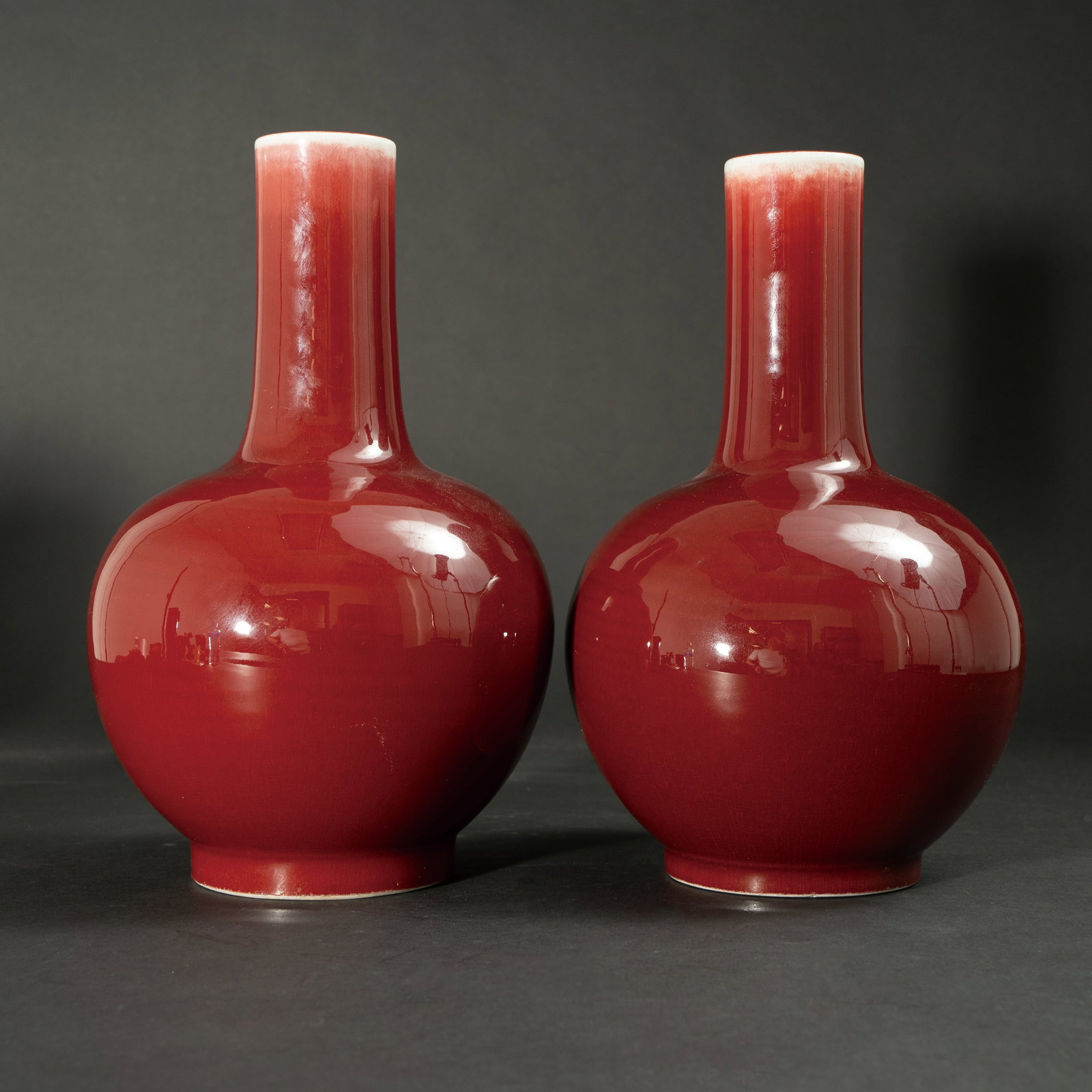 A PAIR OF SACRIFICIAL-RED GLAZED BOTTLE VASES XIANFENG MARK AND PERIOD (1851–1861) 清: A PAIR OF SACRIFICIAL-RED GLAZED BOTTLE VASESXIANFENG MARK AND PERIOD (1851–1861)清咸丰 红釉长颈瓶一对 《大清咸