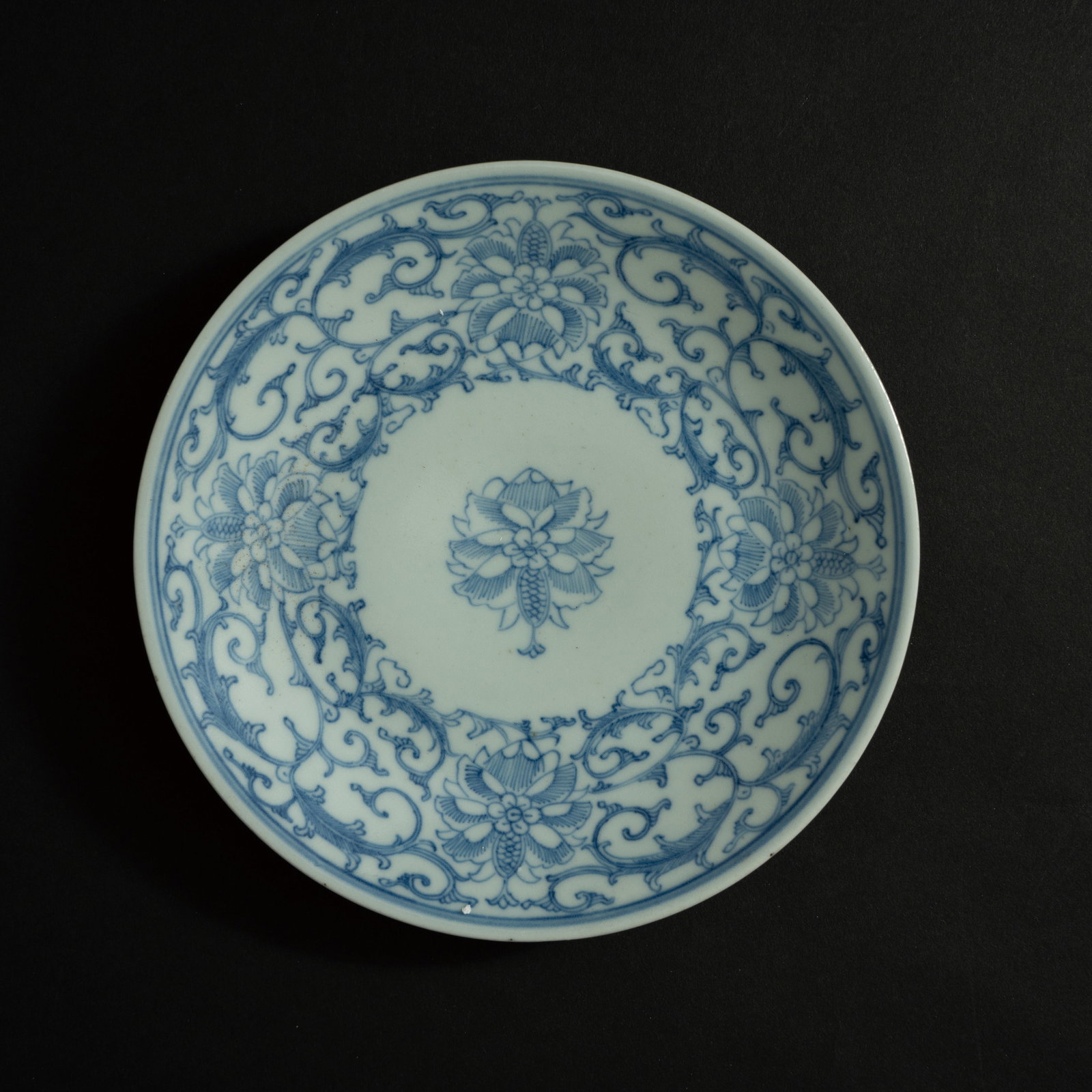 A BLUE AND WHITE 'LOTUS' DISH QING DYNASTY, QIANLONG PERIOD 清乾隆 青花: A BLUE AND WHITE 'LOTUS' DISHQING DYNASTY, QIANLONG PERIOD清乾隆 青花缠枝莲纹盘ESTIMATE: $800 – $1.200DescriptionThis elegantly potted