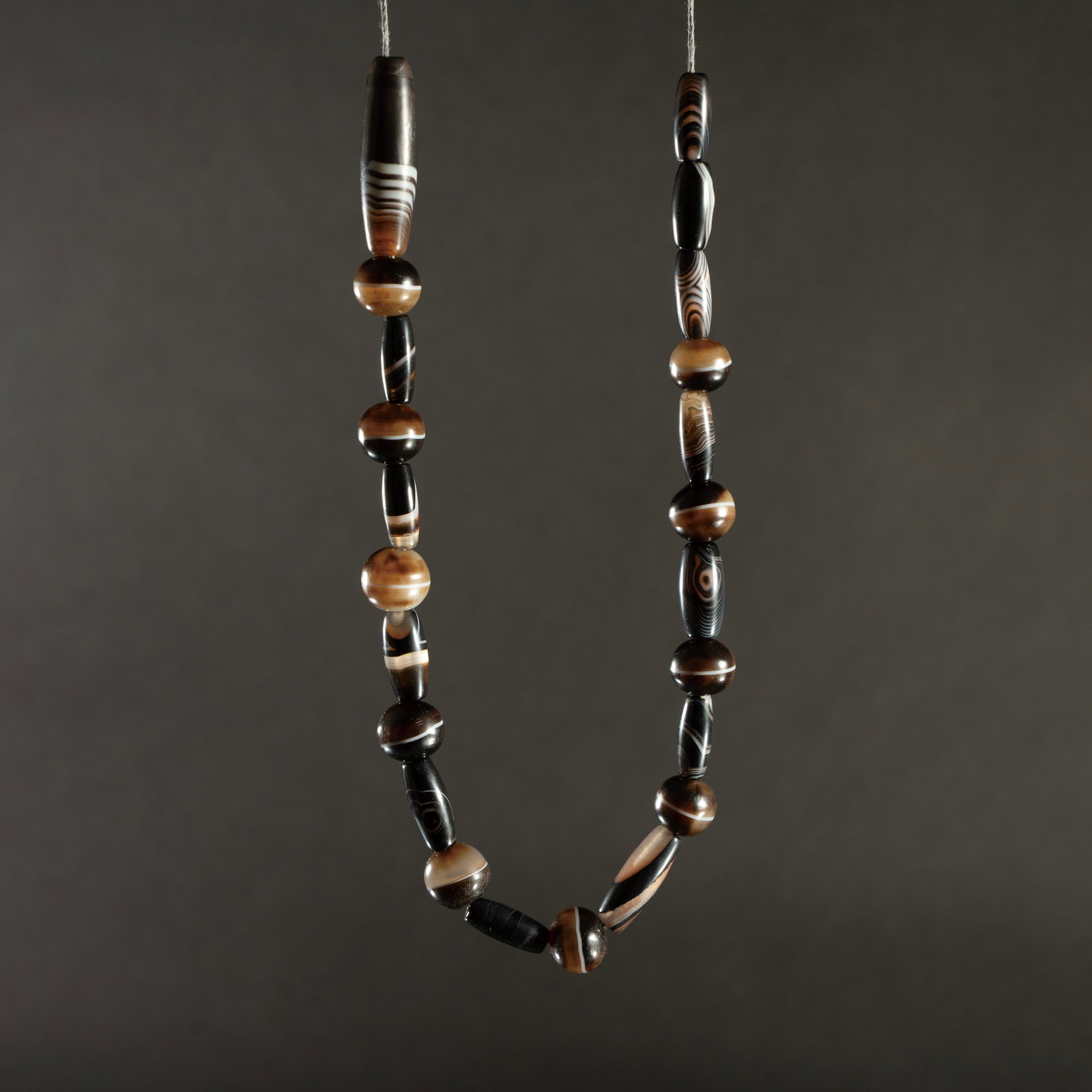A BANDED BLACK AGATE BEAD NECKLACE 黑色缠丝玛瑙项链: A BANDED BLACK AGATE BEAD NECKLACE黑色缠丝玛瑙项链ESTIMATE: $800 – $1.200DescriptionThis necklace is composed of various natural banded black agat