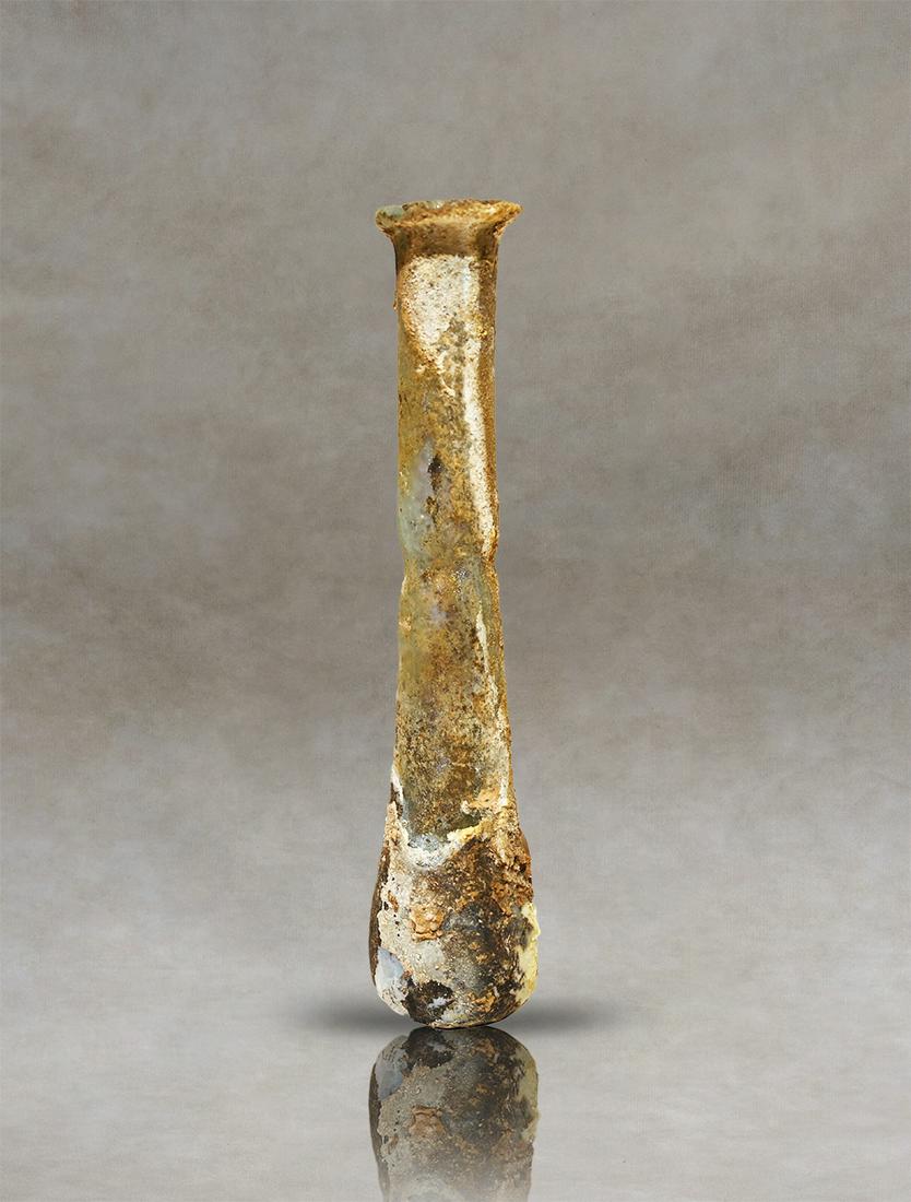 Unguentary bottle. Rome, 1st-2nd century AD.: A spherical body with a flat base, a high, slightly tilted neck and a flat-lipped mouth. This is an authentic example of a blown-glass ointment from the Roman-Imperial period.Inventory code : SG67