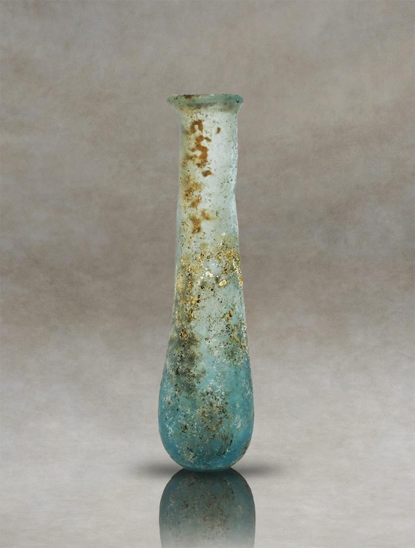 Roman Glass Unguentarium Perfume Bottle: Behold a captivating Roman glass unguentary, believed to have served as an exquisite perfume bottle in ancient times. This exceptional artifact features a flattened rim that gracefully adorns its slen