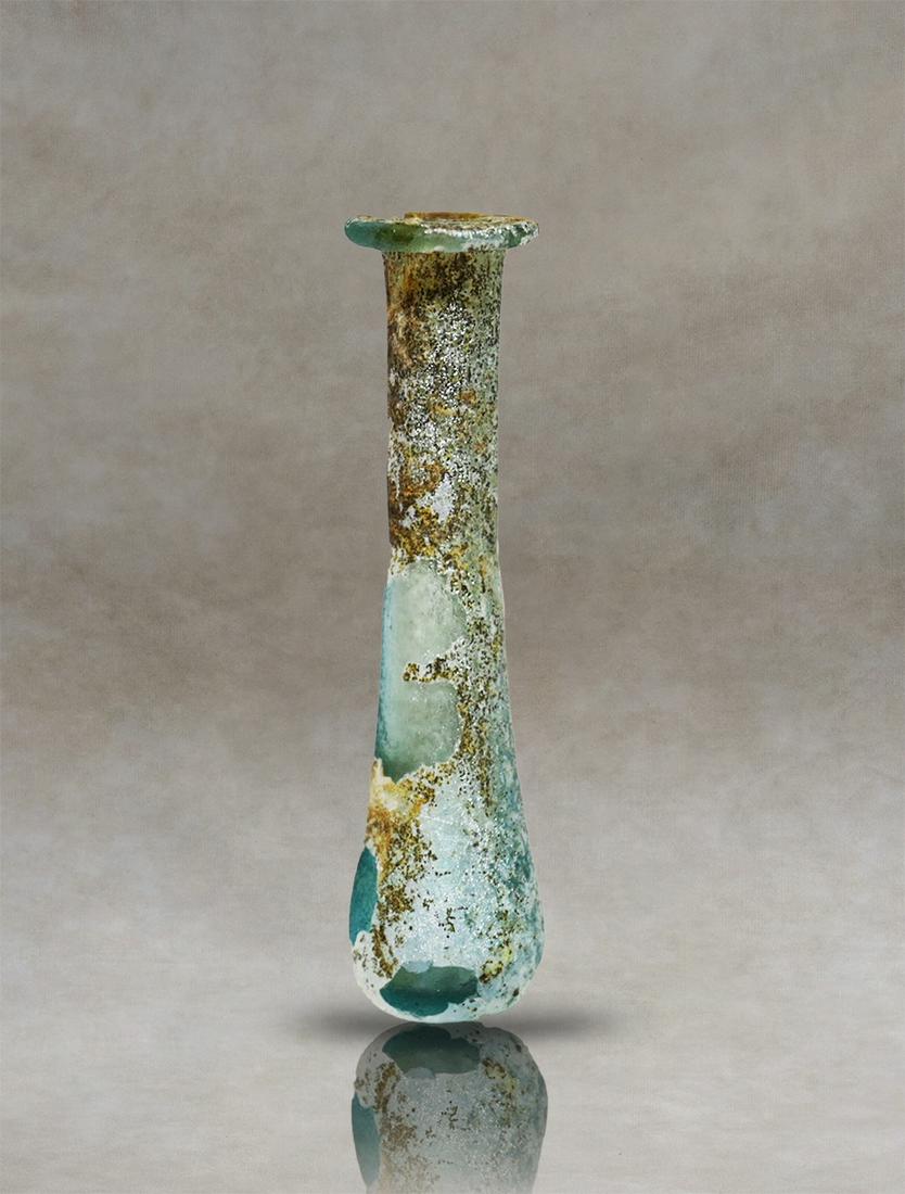 Roman Glass Unguentarium: Presenting an exceptional Roman unguentary crafted from meticulously blown pale blue glass. This distinguished artifact, believed to have functioned as a perfume bottle in ancient times, embodies the