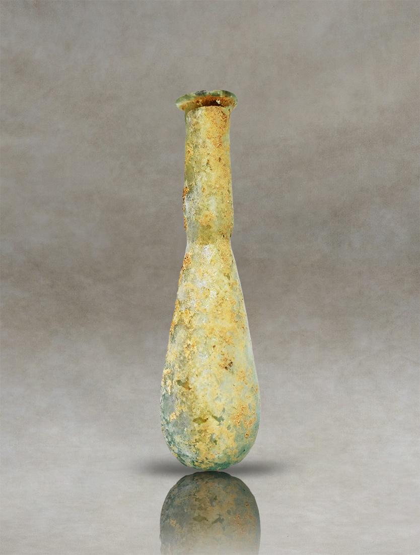 Ancient Roman Glass Unguentarium: Unveiling an exquisite ancient Roman unguentarium, crafted from translucent glass with remarkable artistry. This captivating artifact showcases a pyriform body that gracefully gives way to a cylindric