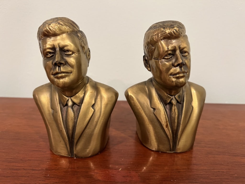 John F Kennedy JFK bust bookends: Brass clad, marked PMC 162 3. Dimensions: H 5.5" x W 4" x D 3" Condition: presenting nicely.