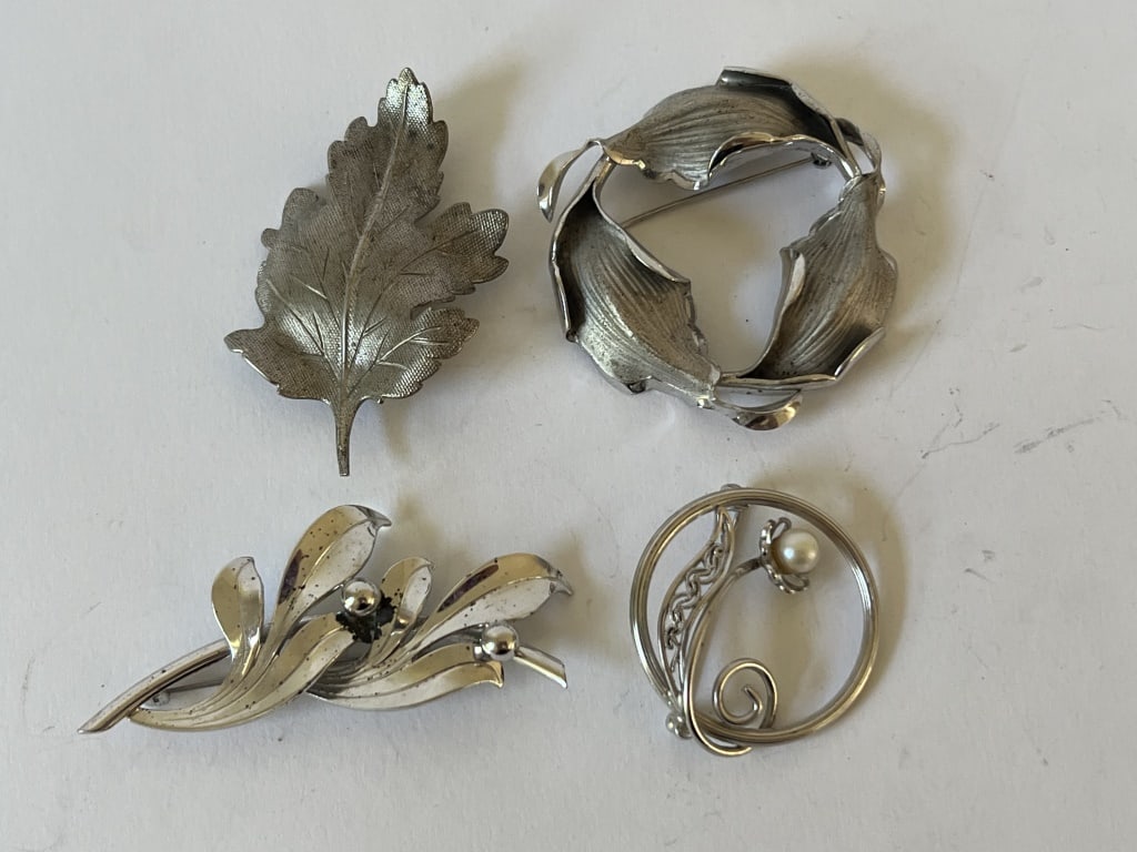 (4) Vintage sterling silver brooches: 4 brooches, all hallmarked including Bond Boyd naturalistic wreath shape, Forstner leaf, 14k gf floral with pearl, and a signed leaf. Dimensions: Leaf: L 2" Total weight: 28 grams Condition: Some tarn