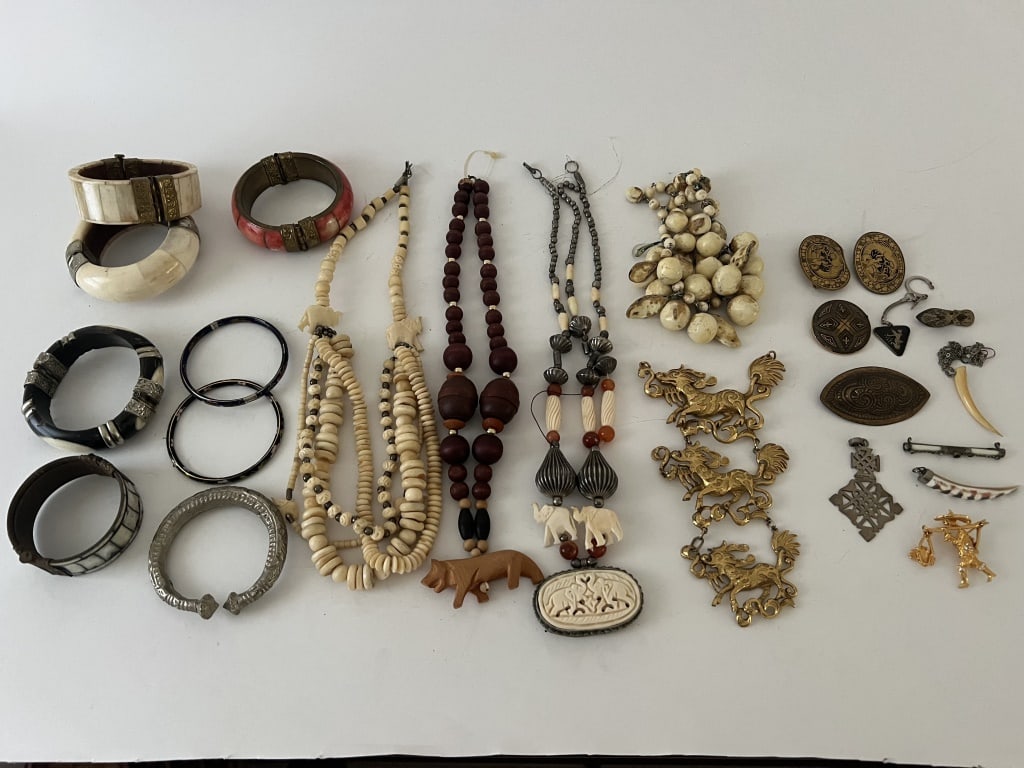 Grouping of Ethnographic jewelry incl Asian: Grouping of mostly Asian inspired jewelry. Bone, shell, brass, cloisonné, three small pieces are sterling silver, etc. Dimensions: Brass tone dragon embellishment: L 7" x W 4" Condition: silver bead