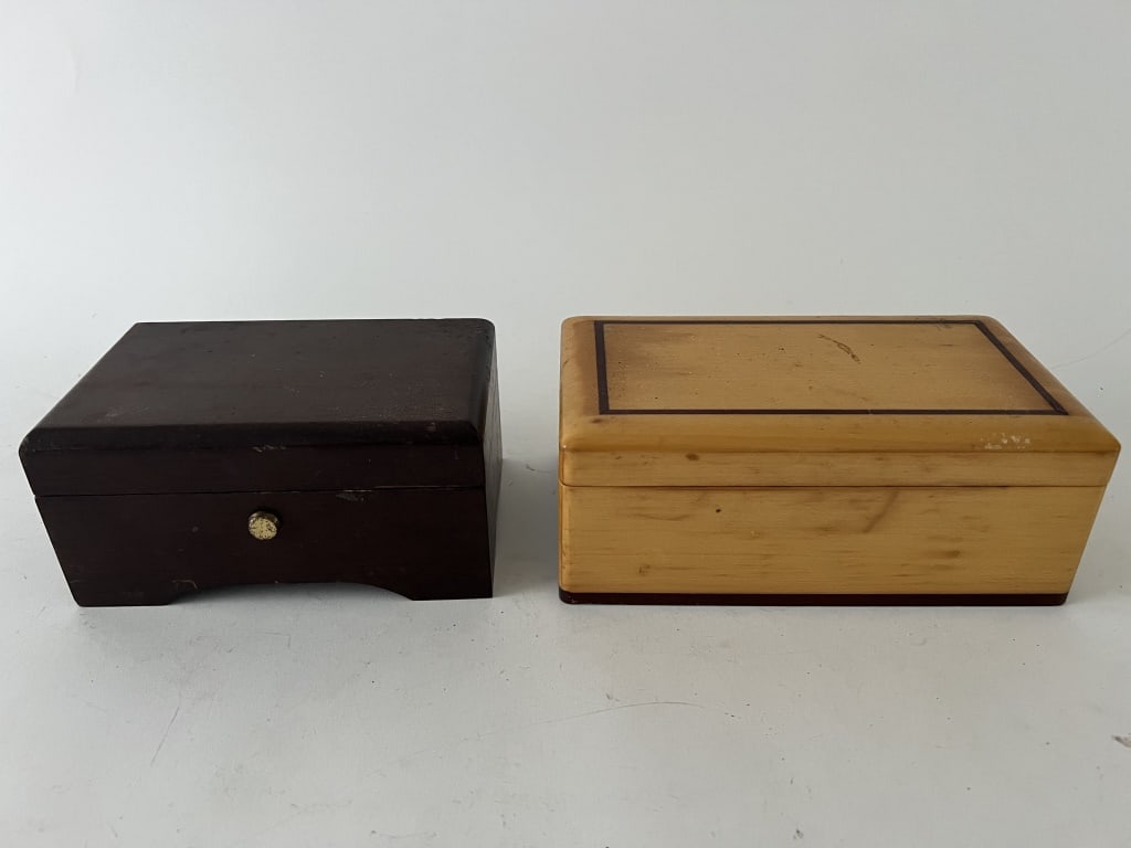 (2) Swiss music boxes including Reuge and Thornes: The smaller a Swiss Reuge box and the larger a Swiss Thornes music box. Dimensions: Larger: L 7" x W 4" x H 2.75" Condition: Both working and showing some scuffs to the surface.