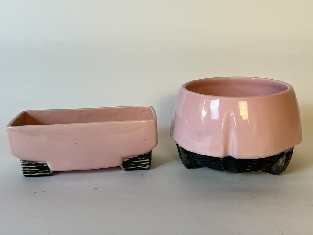 (2) McCoy Pedestal line pink platers: Pretty pink pedestal line, one marked McCoy and one marked USA. Dimensions: Taller: H 4.25" x W 6" Condition: Minor edge chips to one corner.