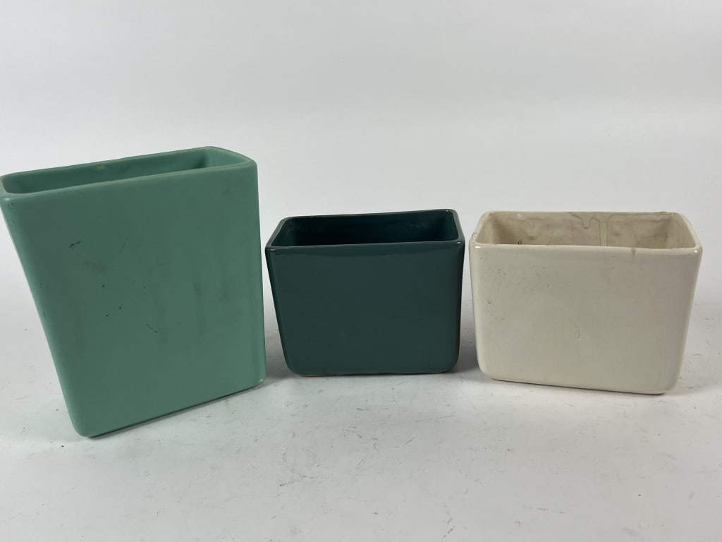(3) McCoy pillow vases: One marked USA, one unmarked and one marked McCoy. Dimensions: Largest: H 6.75" x W 6" Condition: All dirty, white one with edge repair.