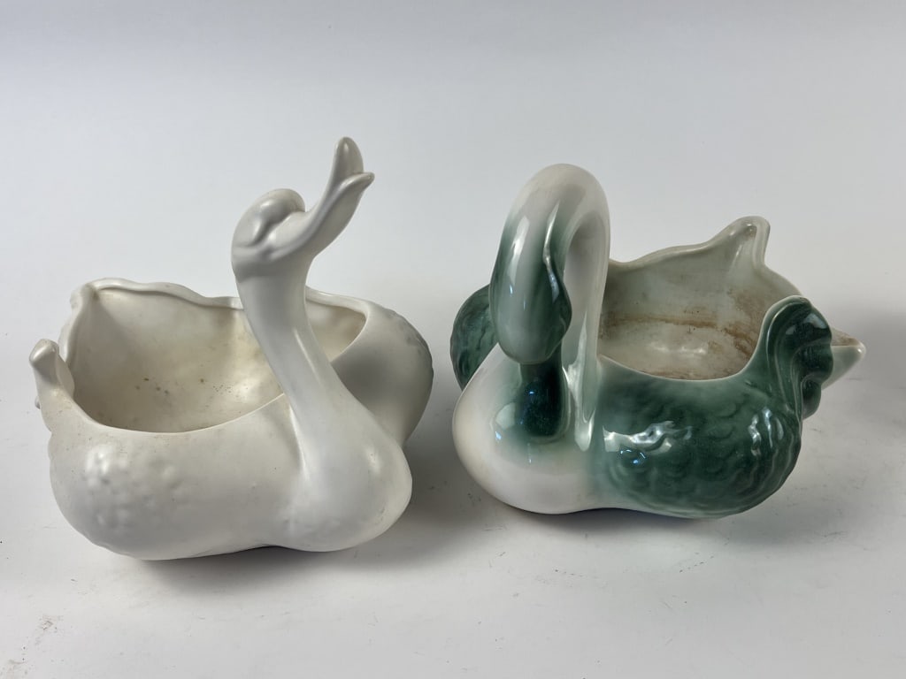 (2) American pottery swan planters: The more colorful one marked Coro Art, the other indistinguishable. Dimensions: H 7.5" x W 10" Condition: Both used, with some staining.