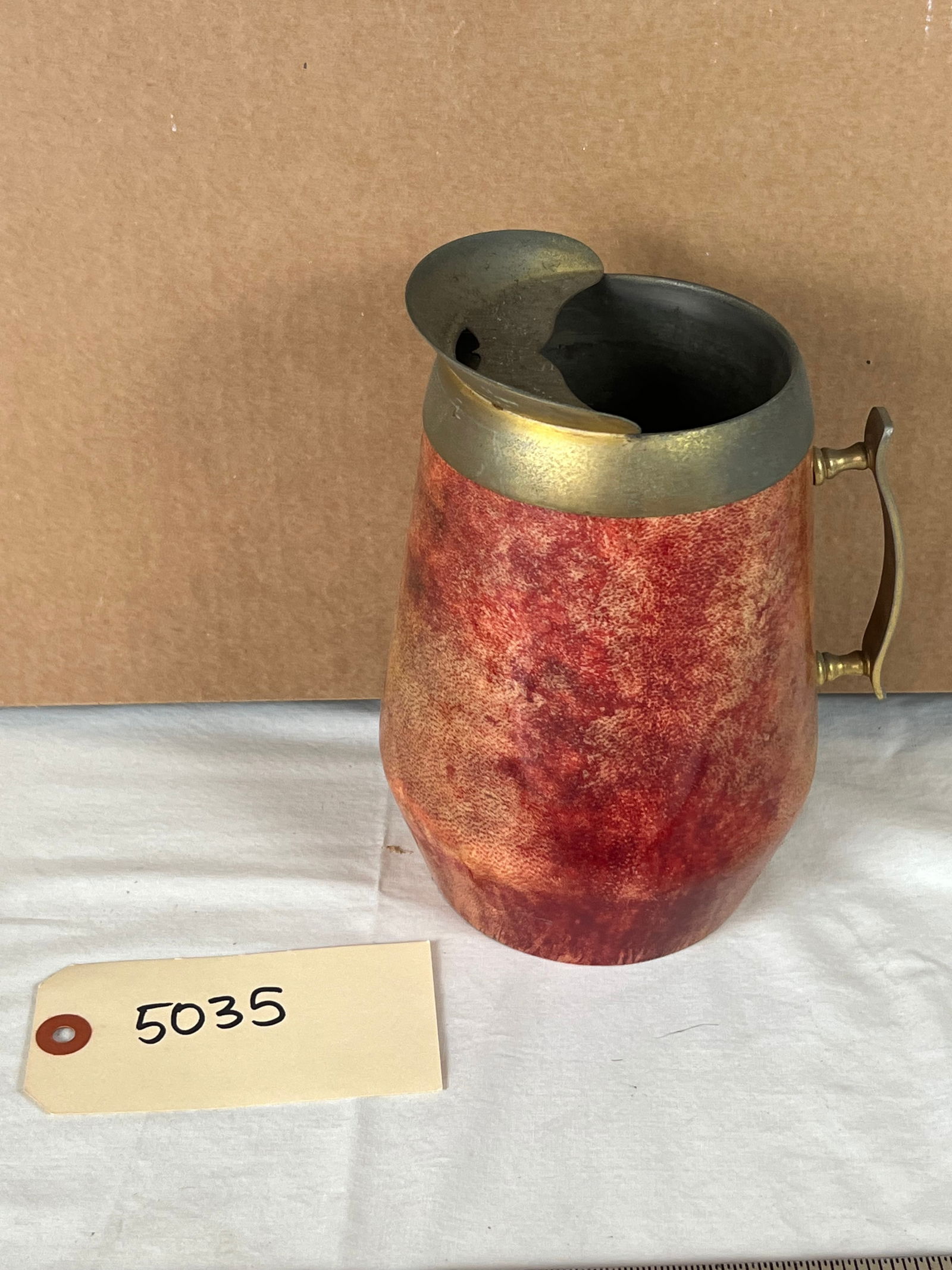 Aldo Tura Pitcher: Goatskin and brass, with label under. Tarnish to handle and spout, normal signs of age.