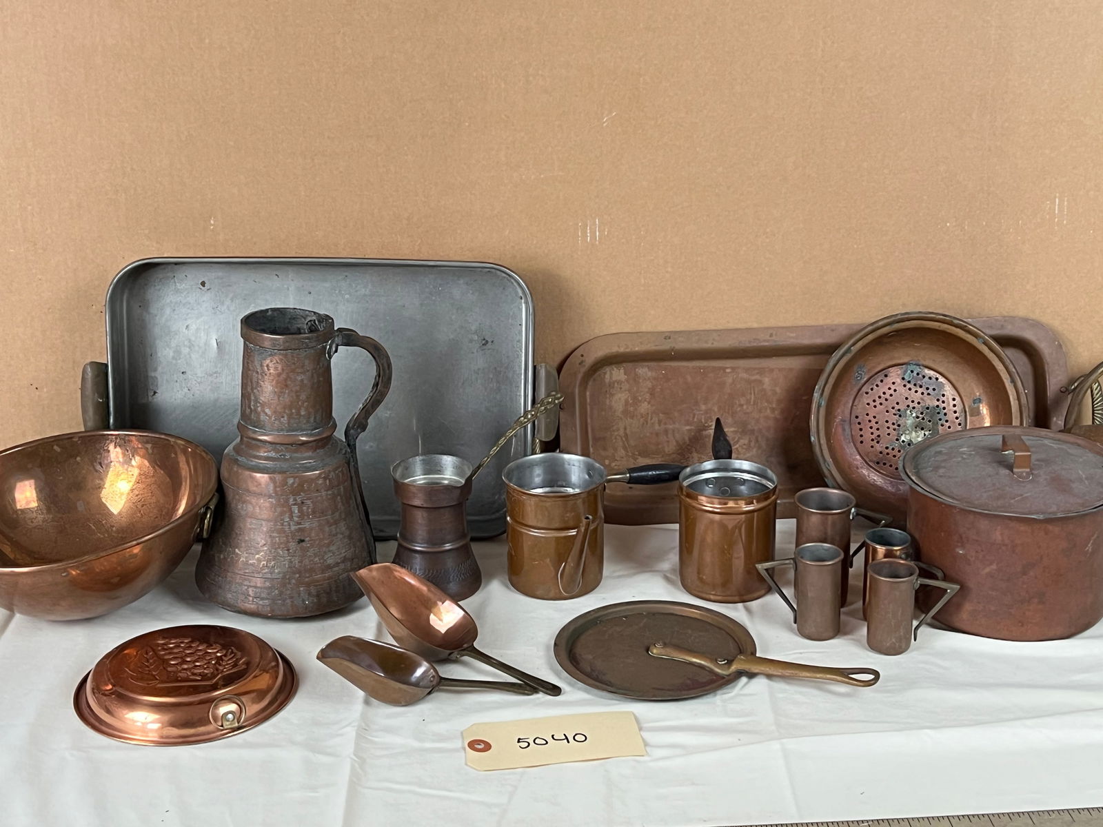 Grouping of copper kitchenware: Bowls, jugs, tops, cups, baskets. etc. All showing signs of use and age.