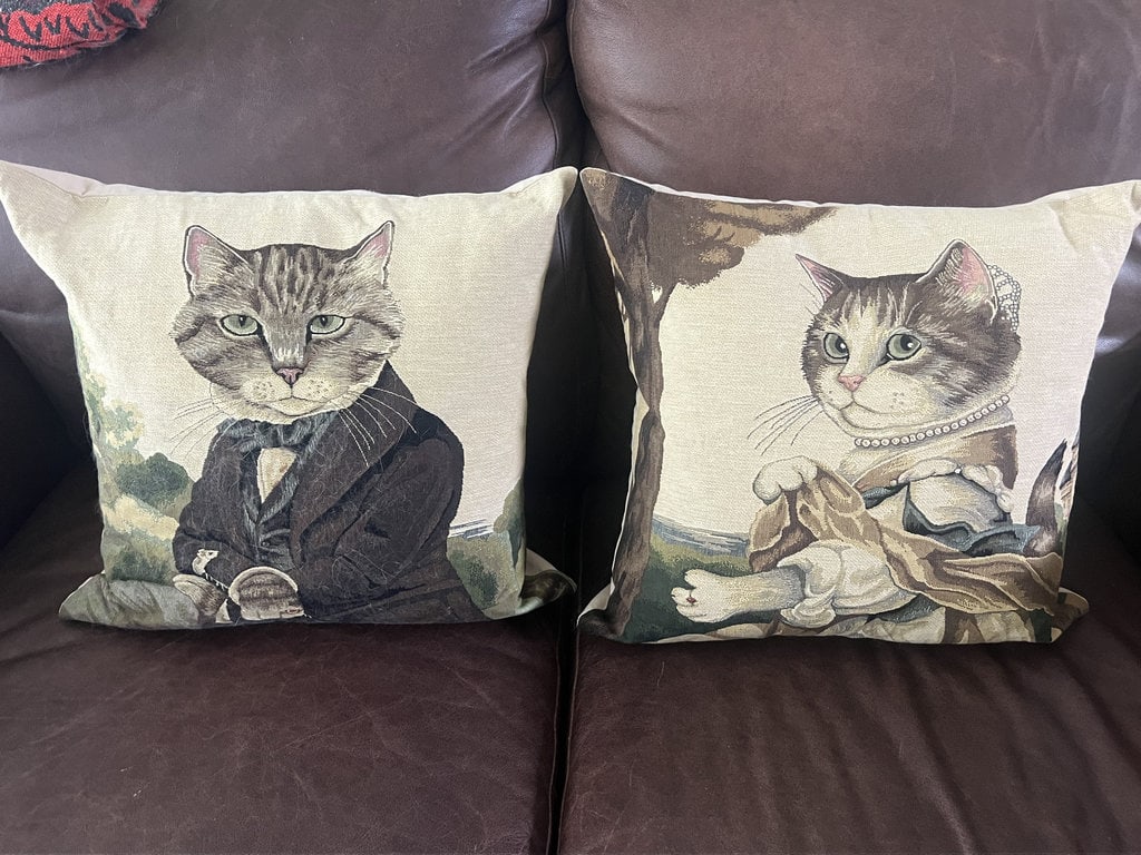 Susan Hebert Cat Royalty Pillows: Tapestry pillows, of cat royalty. Dimensions: 18" square Some cat hair, clean otherwise. Low Estimate: 10.00 High Estimate: 100.00