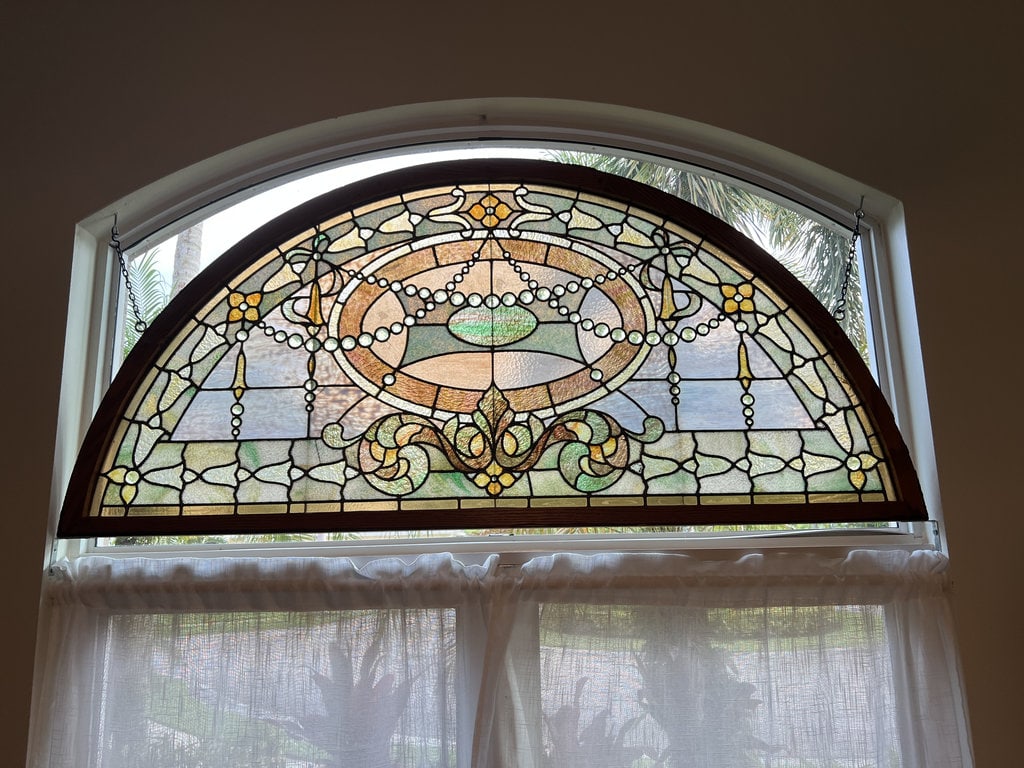 Antique Leaded Glass Arched Window: Slag glass, jeweled, leaded glass window. . Dimensions: L 72" x H 34" A couple cracks. Low Estimate: 400.00 High Estimate: 600.00