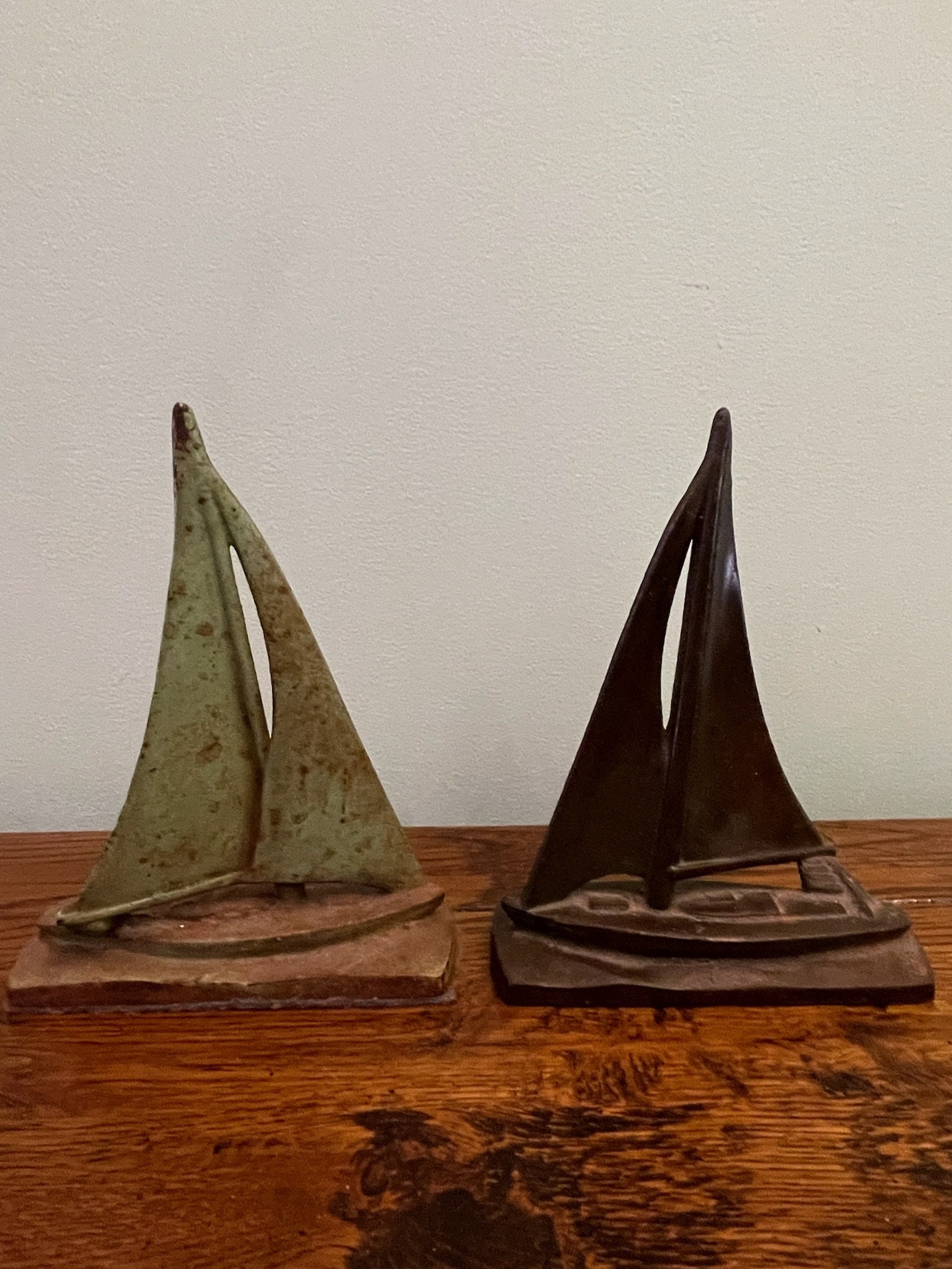 Pair of Cast Iron Sailboat Door Stops: Neither with markings. One with verdigris. Dimensions: H 8.5" x W 6" x D 2" Nice patina, no issues. Low Estimate: 50.00 High Estimate: 150.00