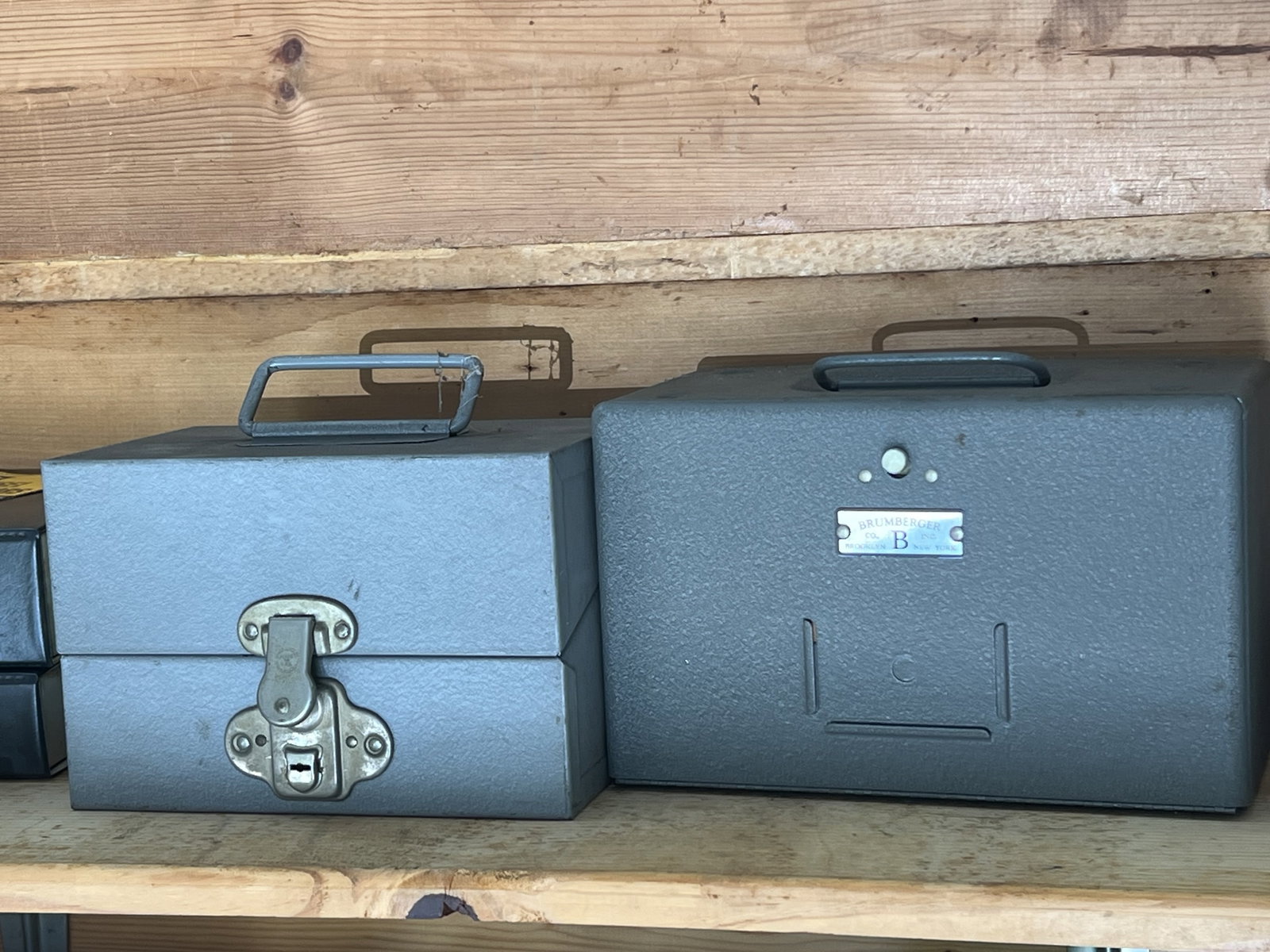 (2) Brumberger Metal Film Containers: Vintage film containers. One marked Brumberger one Eagle Lock. Dimensions: Larger: 6"x 10"x 6". Condition: Nice vintage patina. Low Estimate: 10.00 High Estimate: 1000.00
