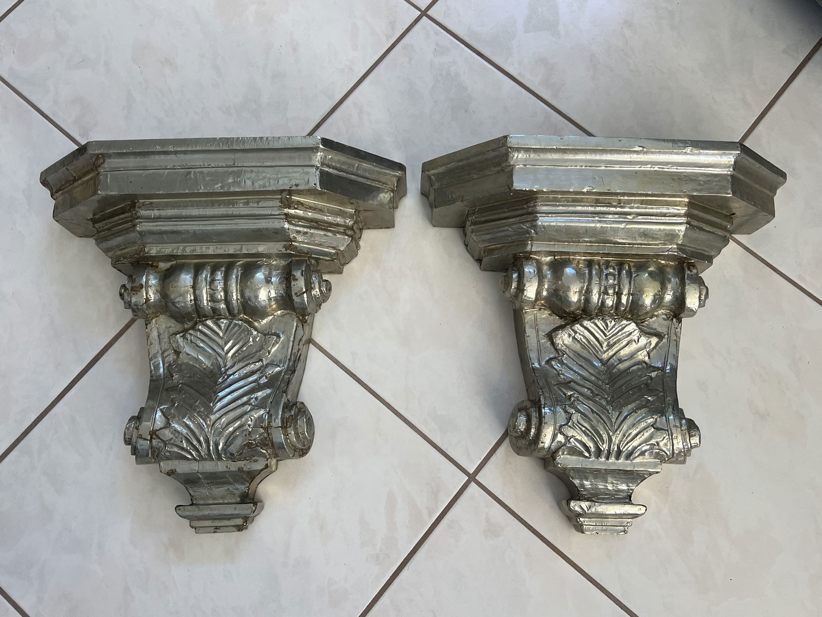 Pair of Silver Overlay or Silver Clad Corbels: Solid wood with silver metal overlay. Paper Made in India sticker on back. Dimensions: H 16" x W 17" x D 6" Condition: Only minor wear. Low Estimate: 200.00High Estimate: 400.00