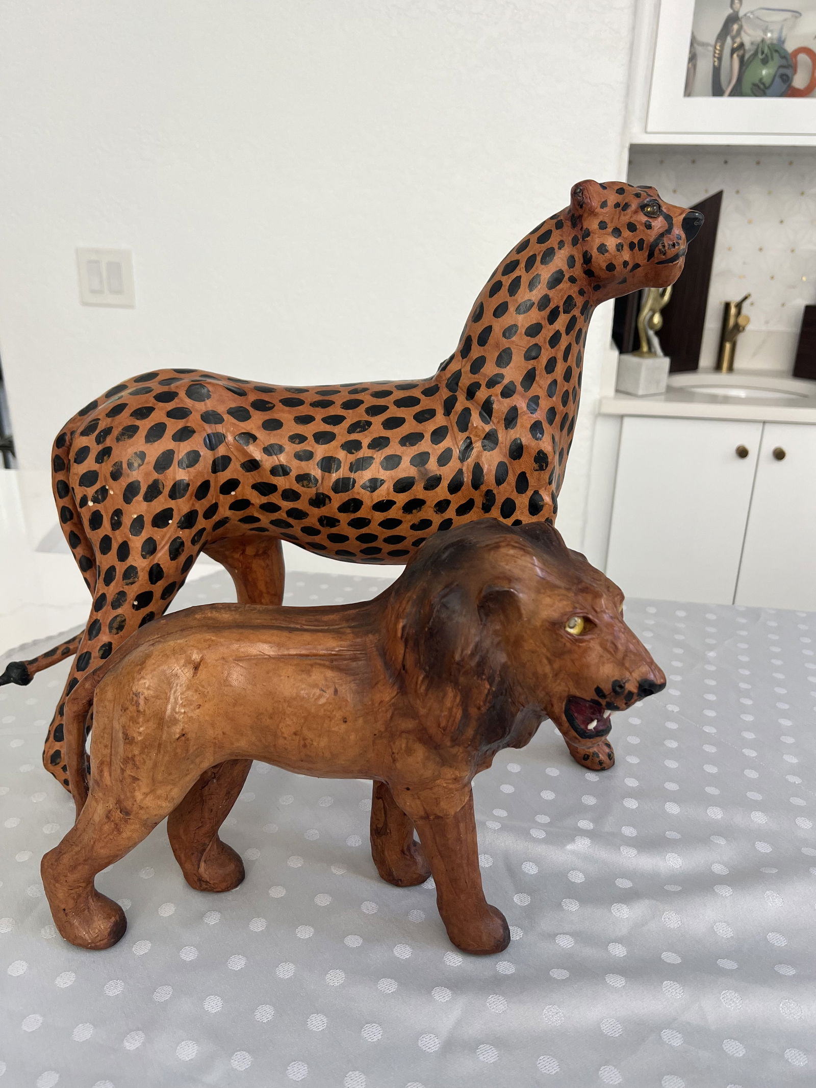 (3) Mid-Century Leather Safari Animals: Three vintage leather animals, a camel, a leopard and a lion. Dimensions: Larger: H 16" x H 16" x W 6" Condition: No whiskers, minor marks. Low Estimate: 150.00 High Estimate: 200.00