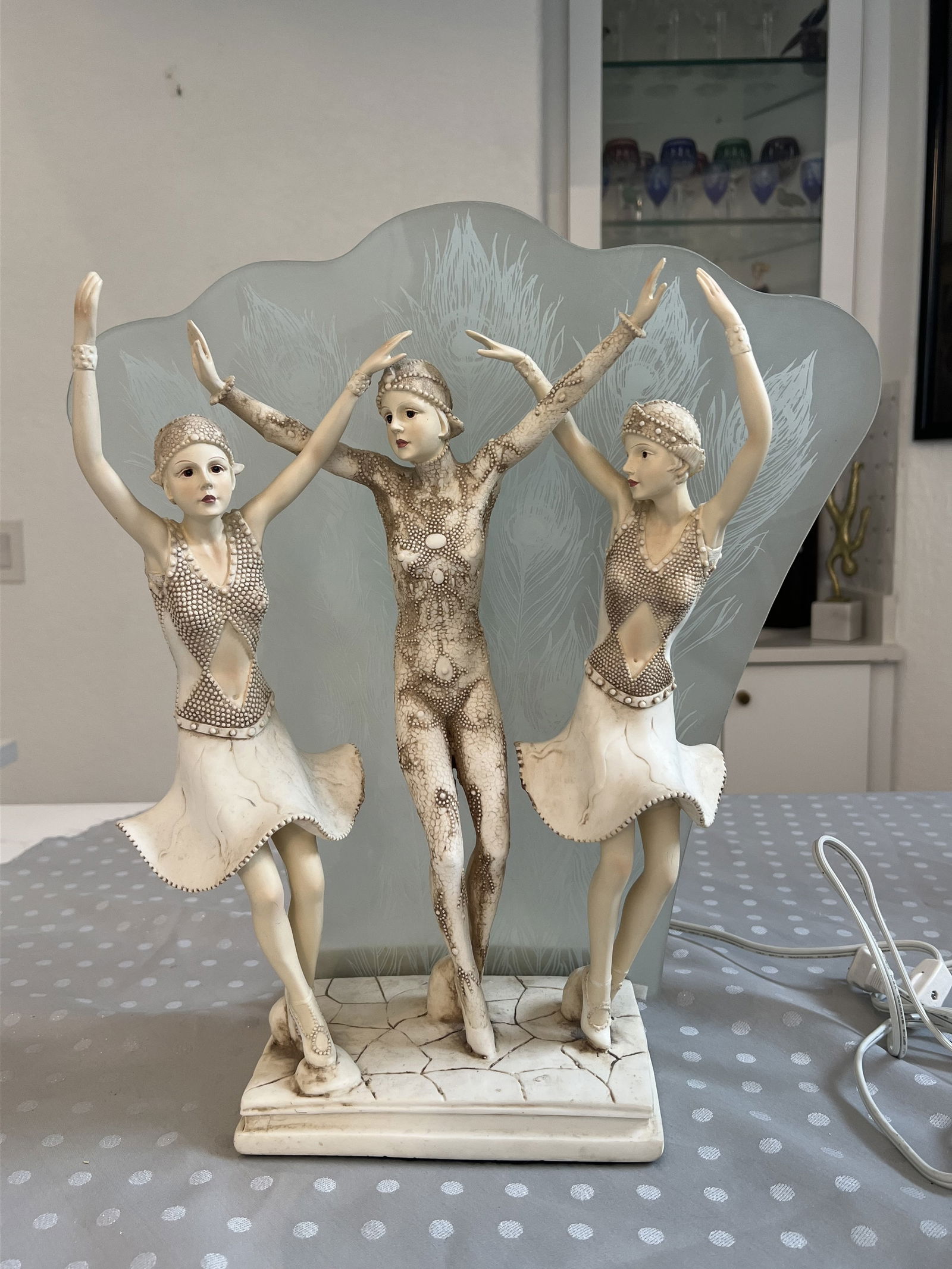 Art Deco Style Dancers Lamp: Three dancers with peacock feather printed glass backdrop, lights up. QH lighting sticker under. Likely 80's. Dimensions: H 17" x W 14" x D 9" Condition, glass piece is removable, minor signs of age,