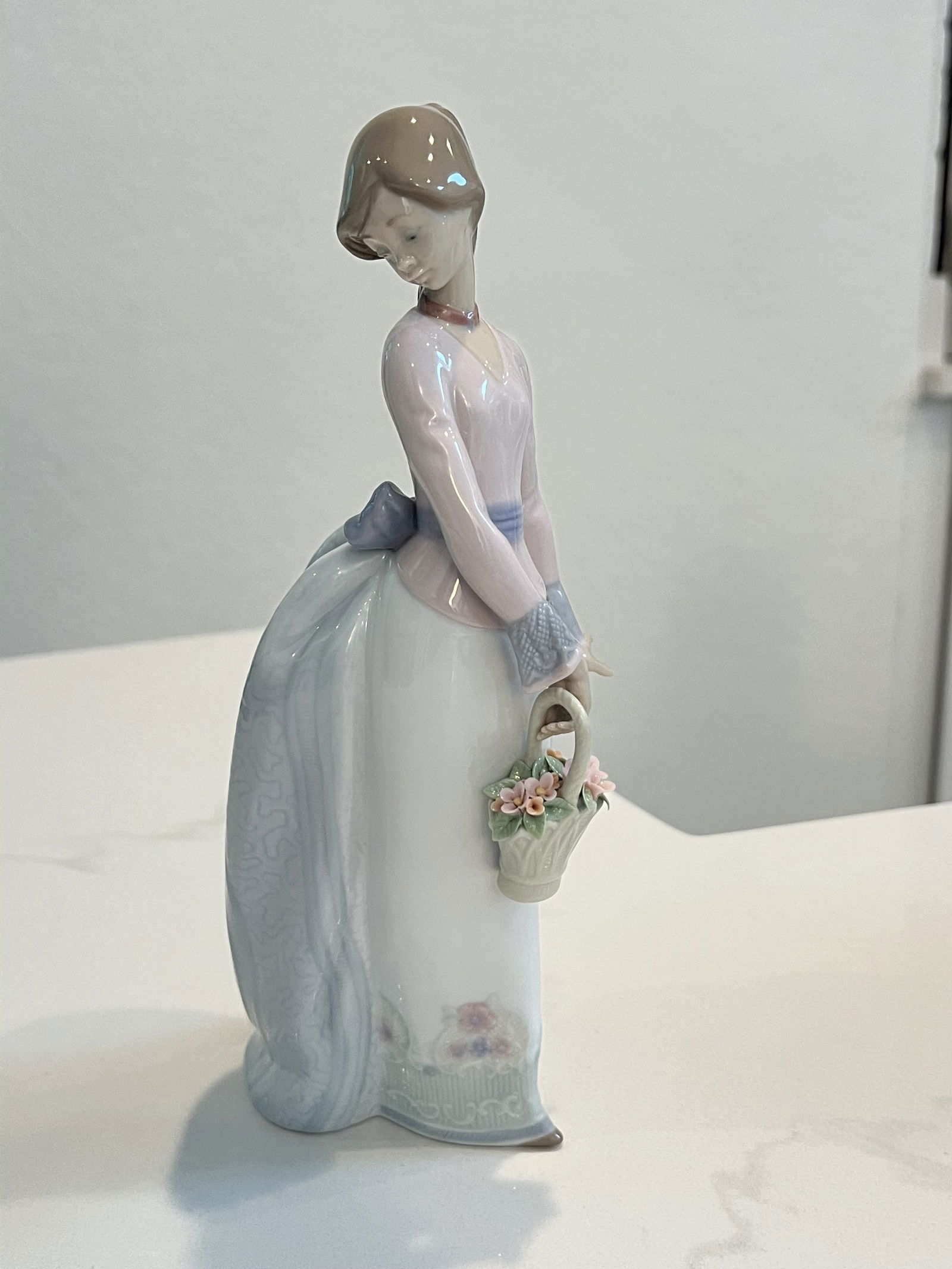 Lladro Basket of Love Figurine: Lladro 7622 "Basket of Love". Dimensions: H 9.5" x W 4" Condition: No issues to note. High Estimate: 200Low Estimate: 100