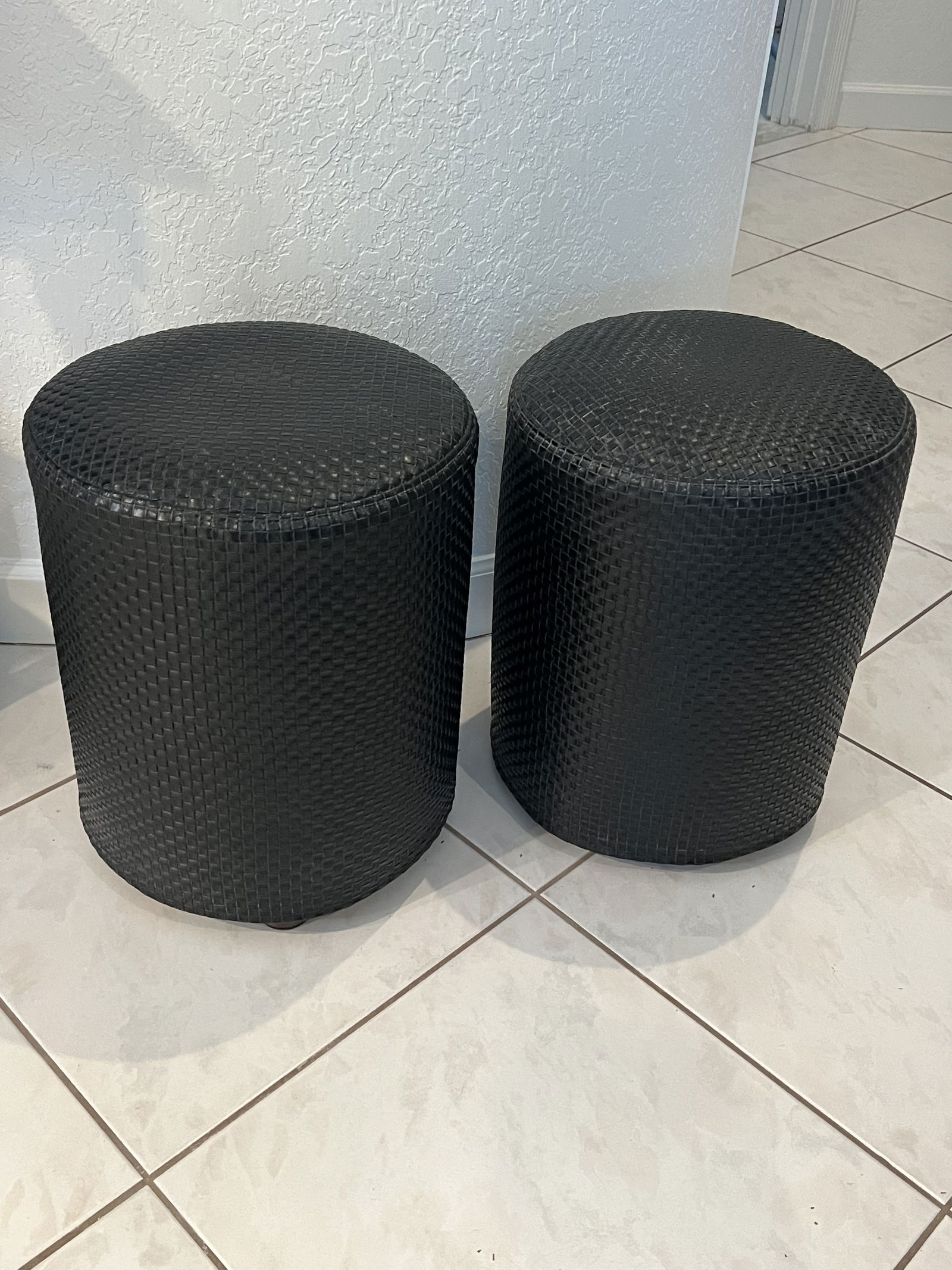 Pair of House of Mai Black Woven Stools: 2 stools. House of Mai, NYC, ottomans. Faux leather woven material over original natural fibers. Dimensions: H 18" x Dia: 14" Condition: Material under is loose and has loss. New covers are