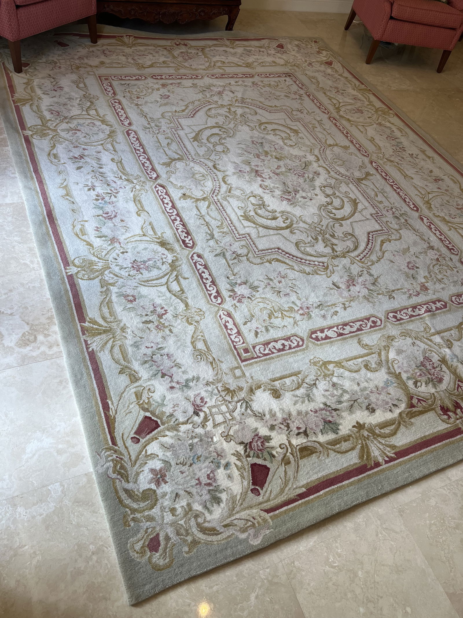 French Aubusson Style Rug: A 9' x 12' hand knotted, wool rug. French Augusson style, with fine details including floral and foliage and ornate scrolling. The colors are muted golds, greens, pink and blue. Condition: Very