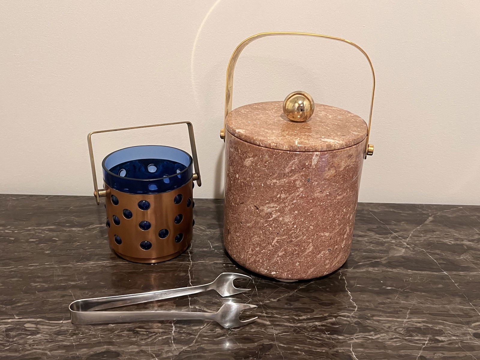 Grouping of Mid-Century Barware inluding Swedish Ice Buckets: Gabis Sweden stainless tongs, A pink marble and brass ice bucket and a blue glass and copper and brass small ice bucket. All vintage, Mid 20th century. Dimensions: Largest bucket: H 8" (to finial,