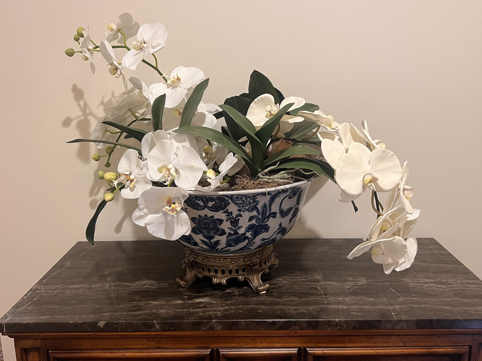 Large Blue and White Chinese Style Centerpiece Bowl with Orchids: Castilian blue and white ceramic centerpiece bowl filled with faux white orchids. Brass footed base. Dimensions: Overall: H 10" x W 20" Bowl: H 9.5" x Dia: 16" Condition: no issue to note. Low
