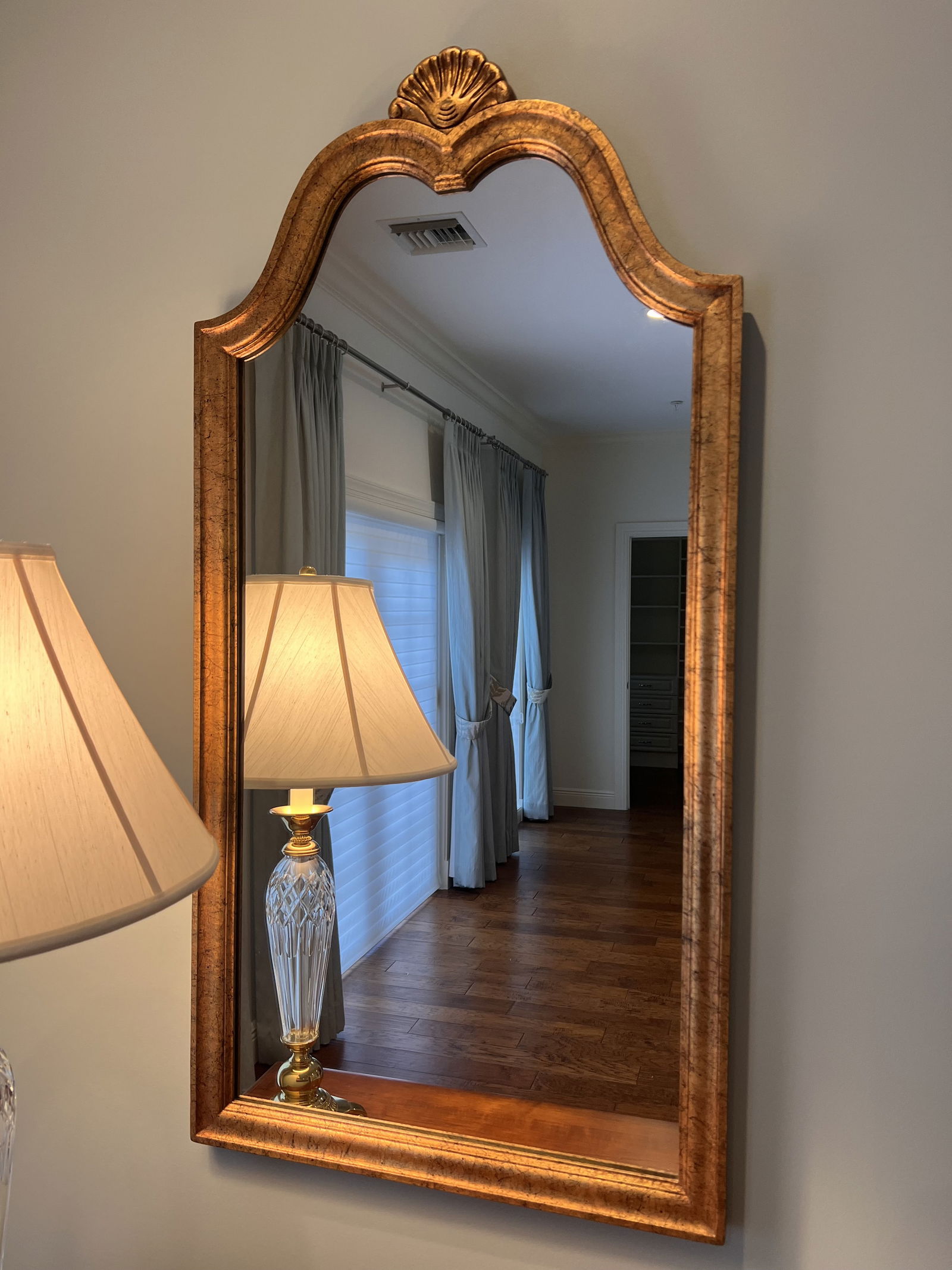 Vintage French Regency Gold Mirror: Gold and black finished frame, scalloped shell crest detail at the top. Dimensions: H 46" x W 23" Condition: Presenting well, minor signs of age. Low Estimate: 10.00High Estimate: 10000.00