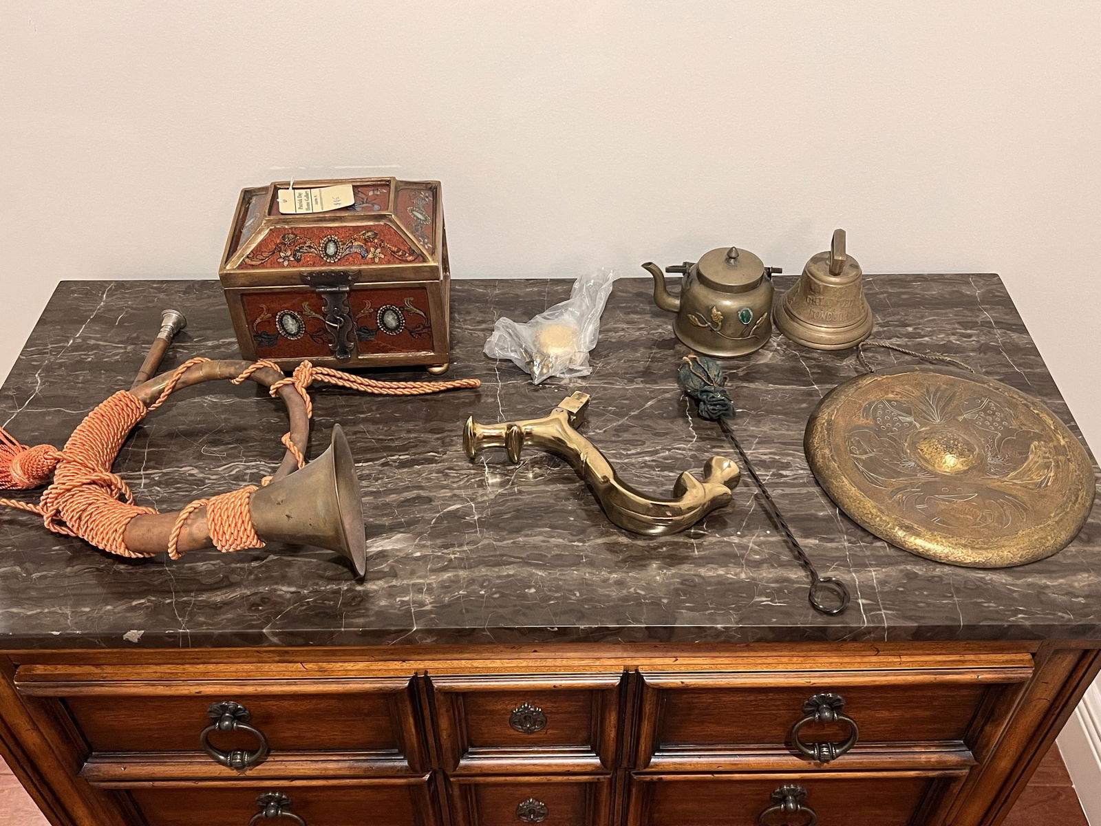 Grouping of Brass Decorative Objects: A copper hunting horn, a large door knocker, an Asian tea pot and gong , Patrick Day Home Gallery reverse painted box and a bell. Dimensions: Gong: Dia: 9" Condition: All showing normal signs of age.