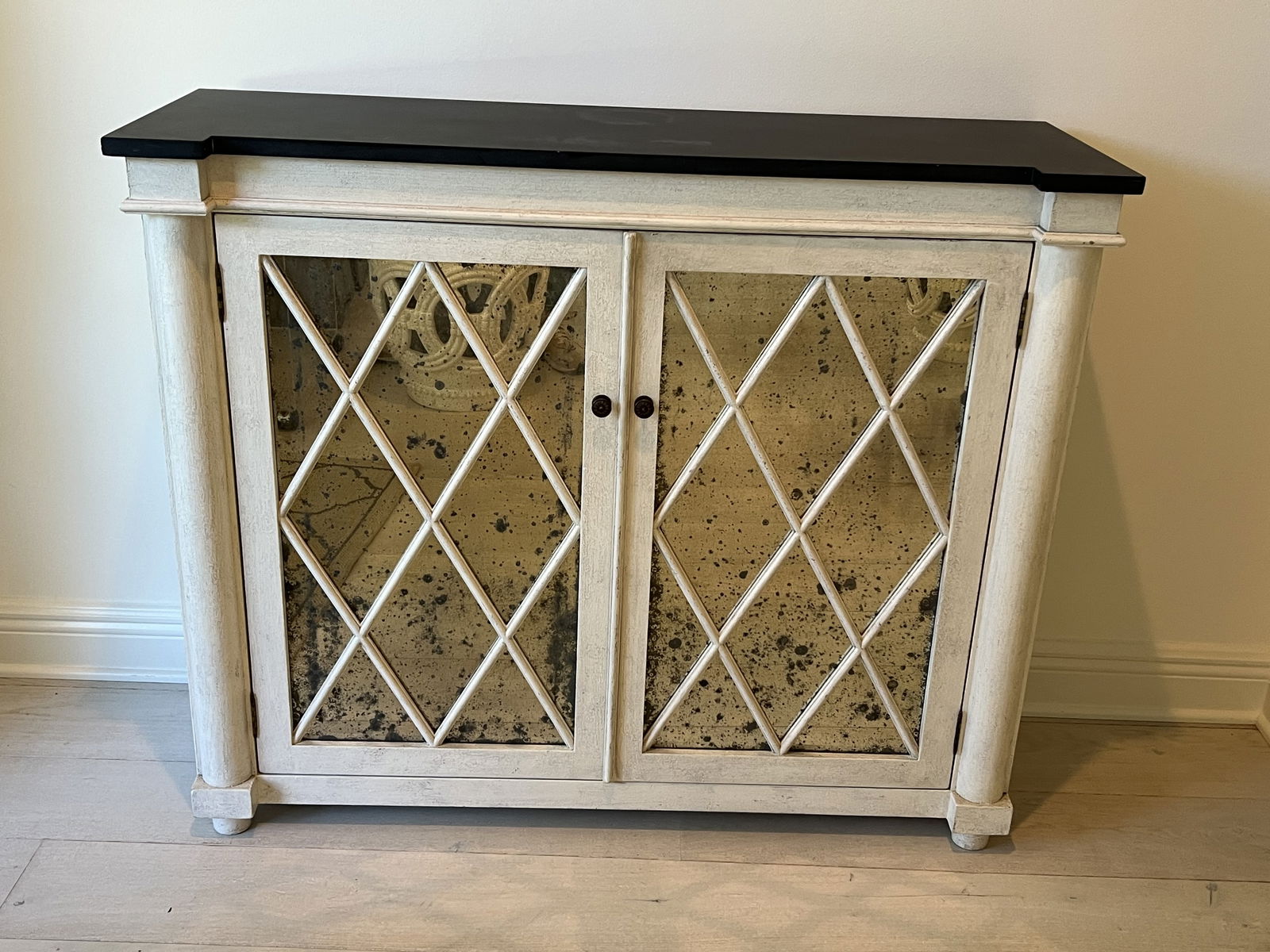Slate Top Mirrored Console or Entry Table: Transitional white wood entry cabinet with columns, antiqued mirror with diamond patterened front and sides and black slate top. No manufacturers marks. Dimensions: H 35.5" x W 42.5" x D 14.5"