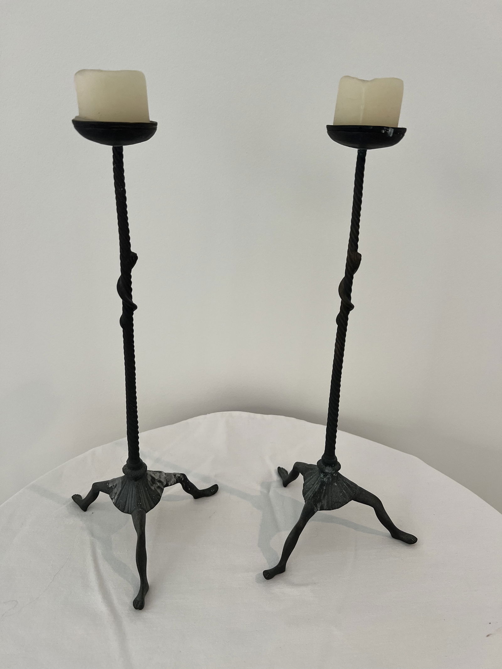 Pair of MMA Candleholders: Metropolitan Museum of Art, three footed and skirted candlesticks, metal. Dimensions: H 16" x W 7" Condition: Signs of use including wax. Low Estimate: 10.00High Estimate: 10000.00