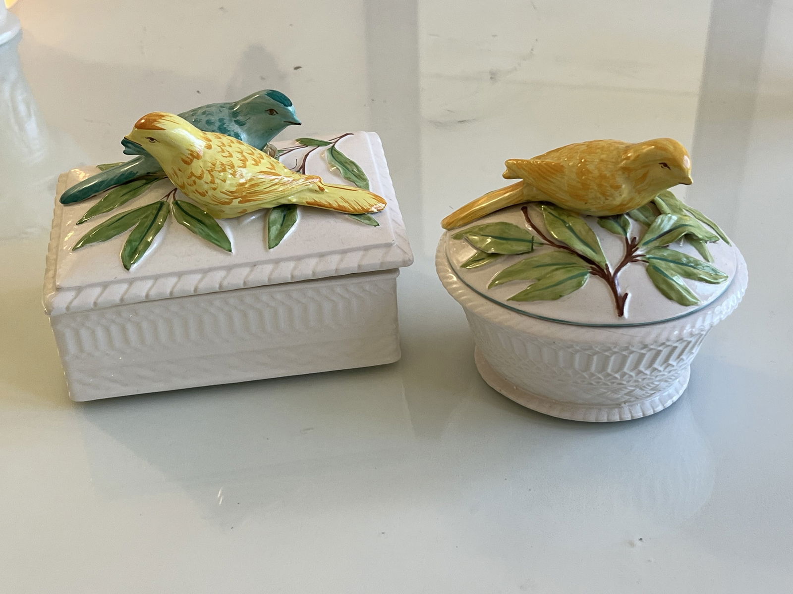 (2) Italian Ceramic Boxes with Birds: Ceramic boxes, Made in Itlay showcasing colorful bird tops and classic Italian basket design. Dimensions: Larger: H 5.5" x W 6.5" x D 5" Condition: One leaf appears to be repaired but it could be in