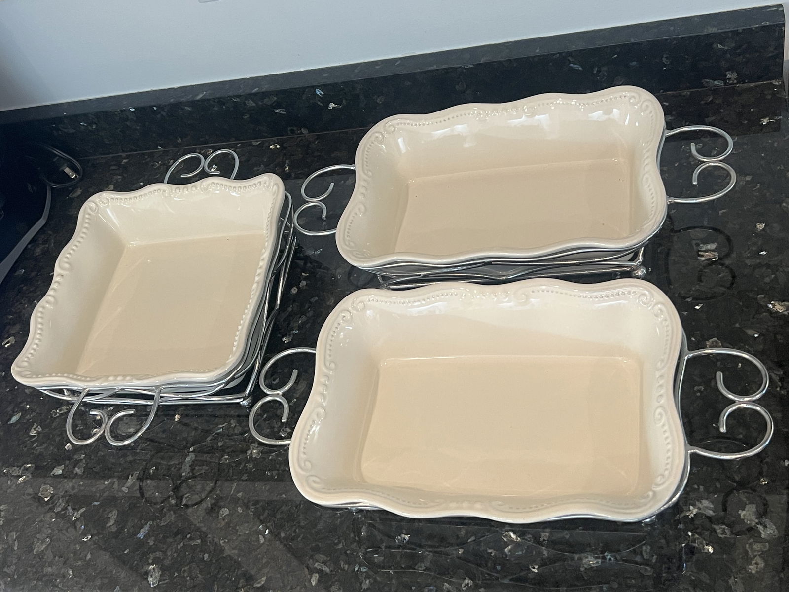 (3) Off White Ceramic Dishes in Silver Serving Trays: No makers marks. Dimensions: Square 10.5" (no including metal holders) Low Estimate: 10.00High Estimate: 10000.00