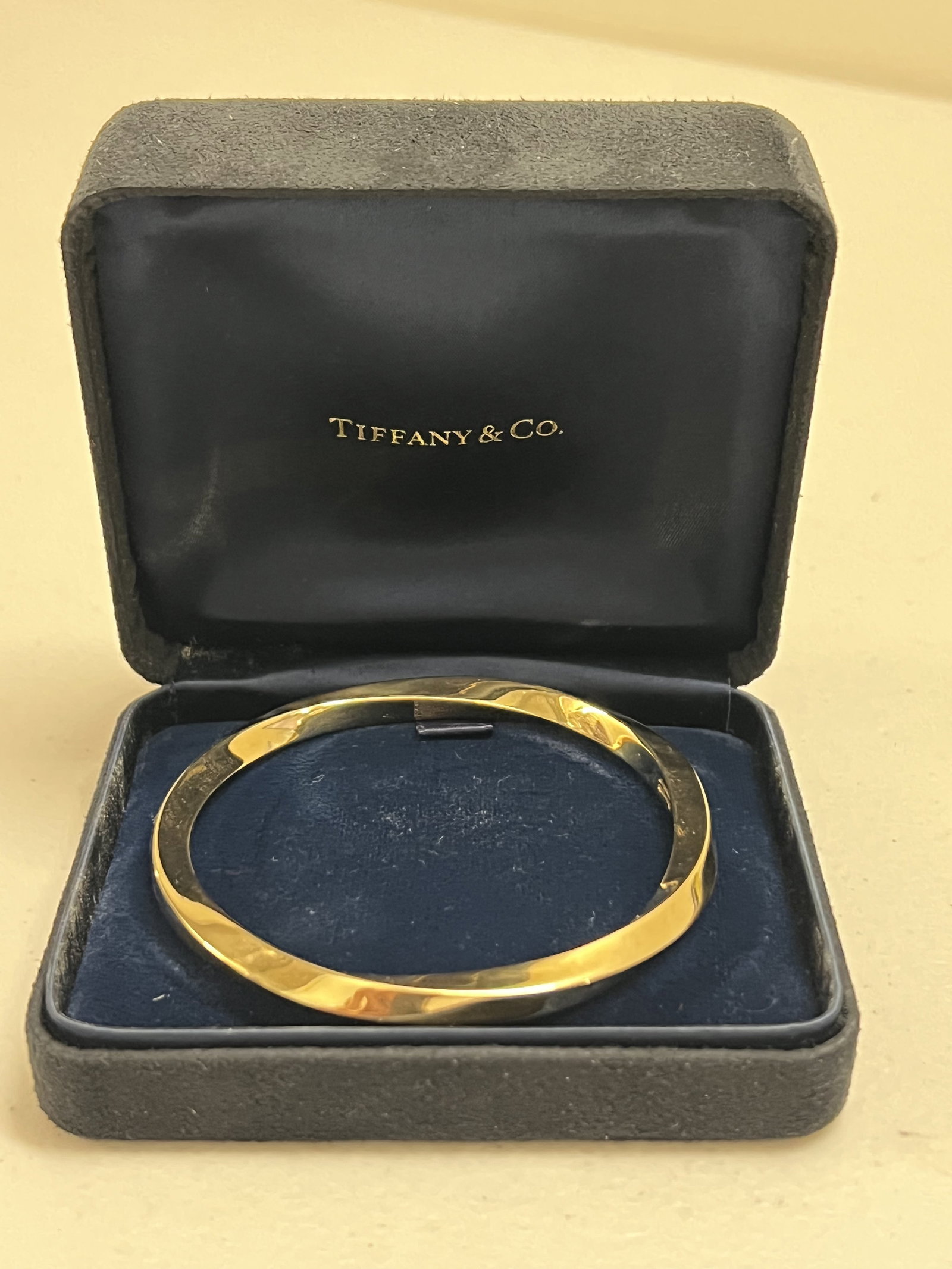 Tiffany & Co Twisted Yellow Gold Bangle: A Tiffany & Co 18k yellow gold twisted bangle. Hallmarked Tiffany & Co 750 Italy. Opening measures: 2.5" Weight: 34.3 grams Condition: Only lightly used. Low Estimate: 10.00 High Estimate: 10000.00