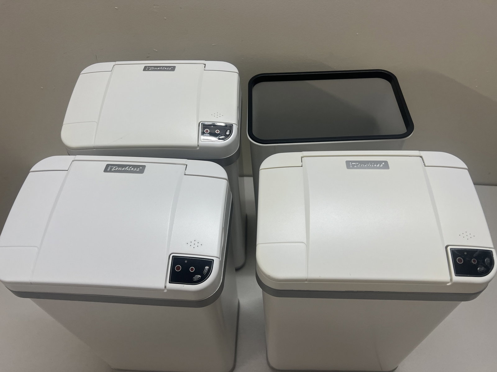 (4) White Touchless Automatic Sensor Trash Cans: White metal. Dimensions: H 17" x W 10.5" Condition: Used, minor imperfections, clean, one missing top. Low Estimate: 10.00 High Estimate: 10000.00